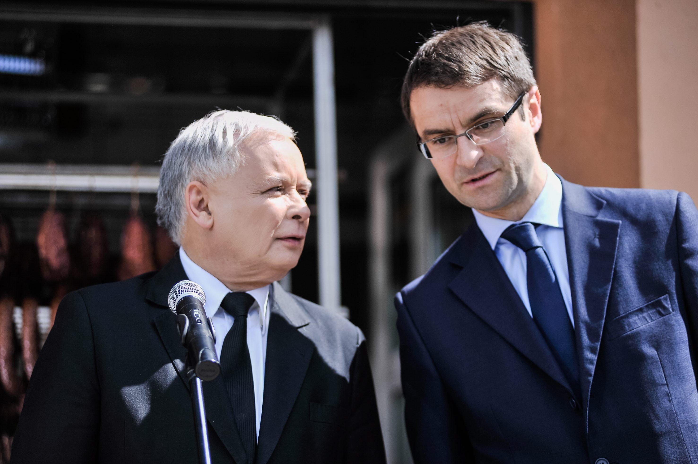 Młodszy wyższy mężczyzna (Tomasz Poręba - z prawej) pochyla się ku starszemu i niższemu (Jarosław Kaczyński z lewej)