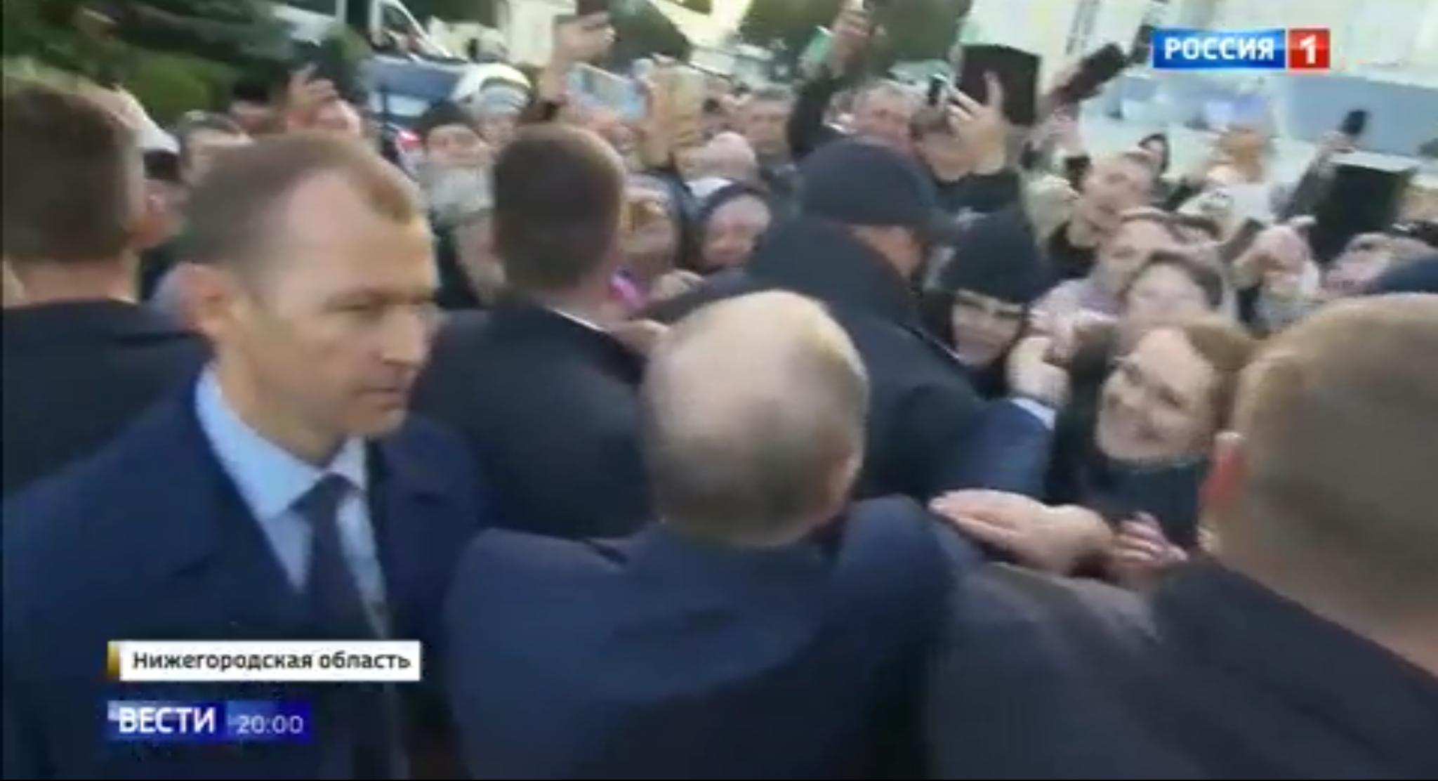 Putin wita się z ludxmi odgrodzony od nich dwoma rzędami ochroniarzy