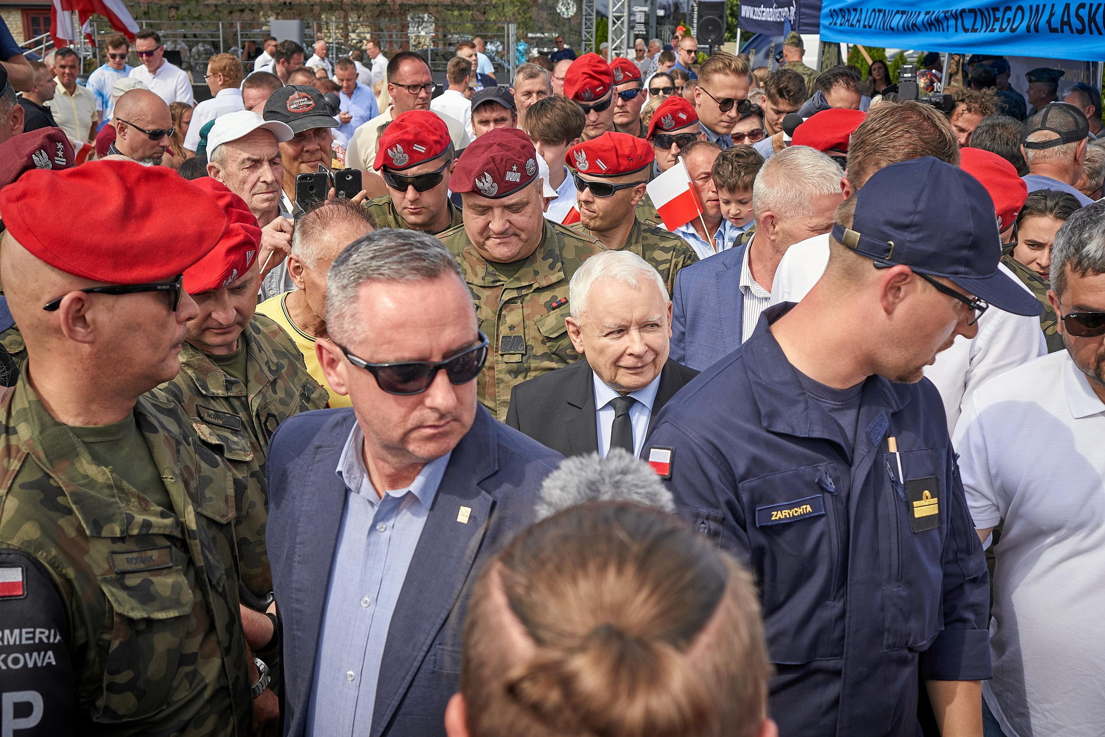 Jarosław Kaczyński idzie w otoczeniu żołnierzy w czerwonych beretach