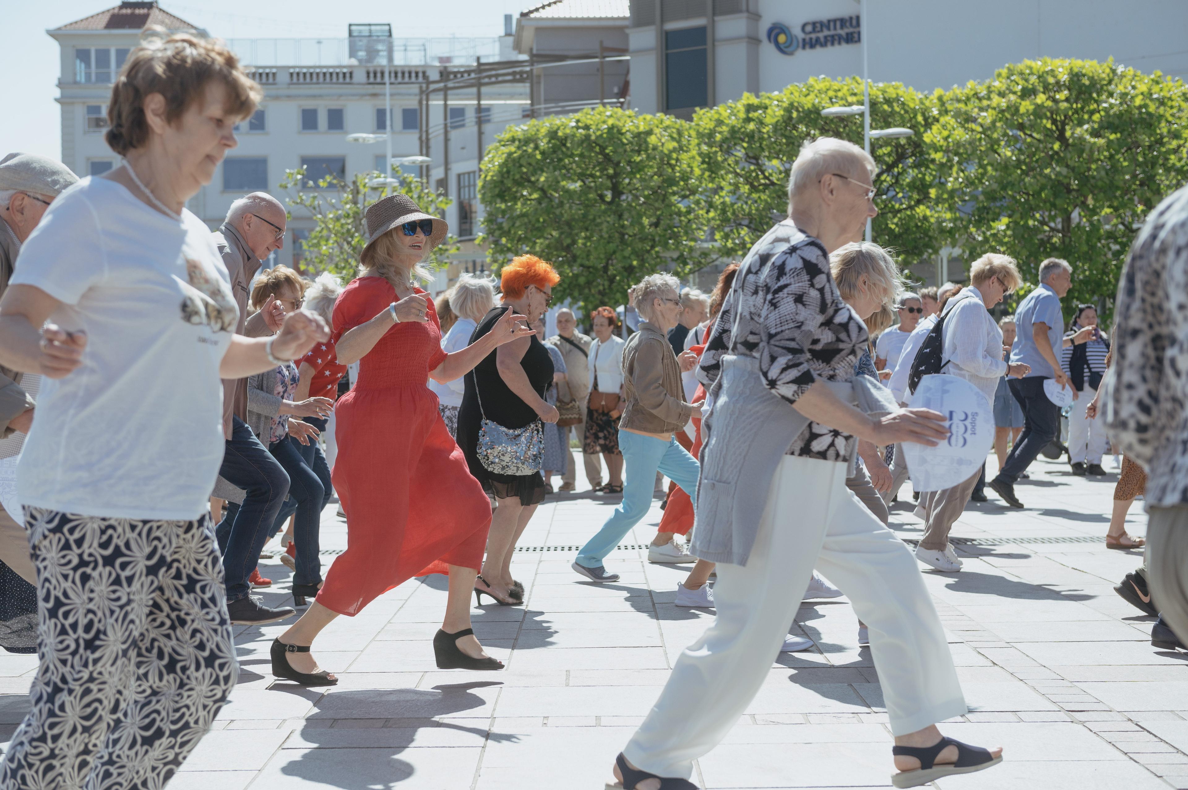 Starsze osoby tańczą na miejskim placu