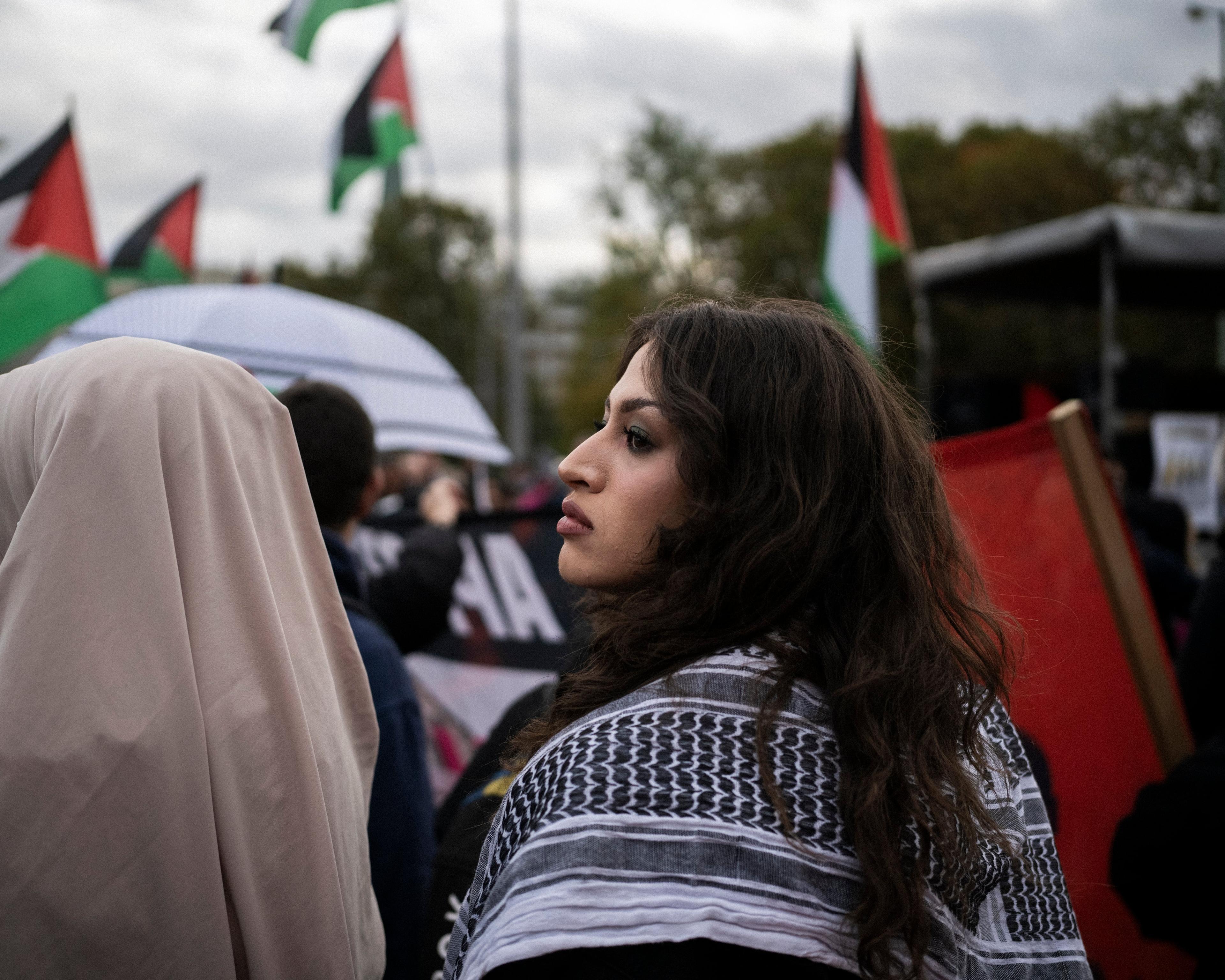 Dziewczyna z arafatką na ramionach w tłumie protestujących