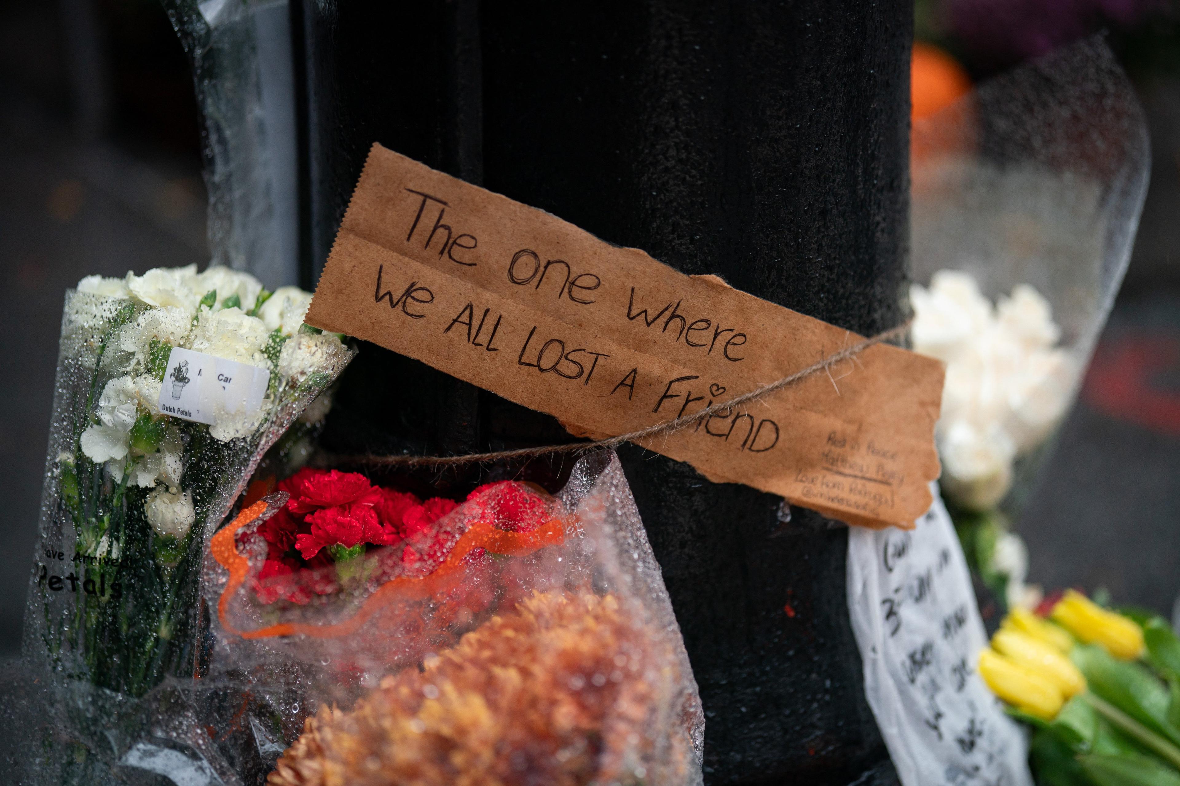 kwiaty i napis "the one where we all lost a friend"