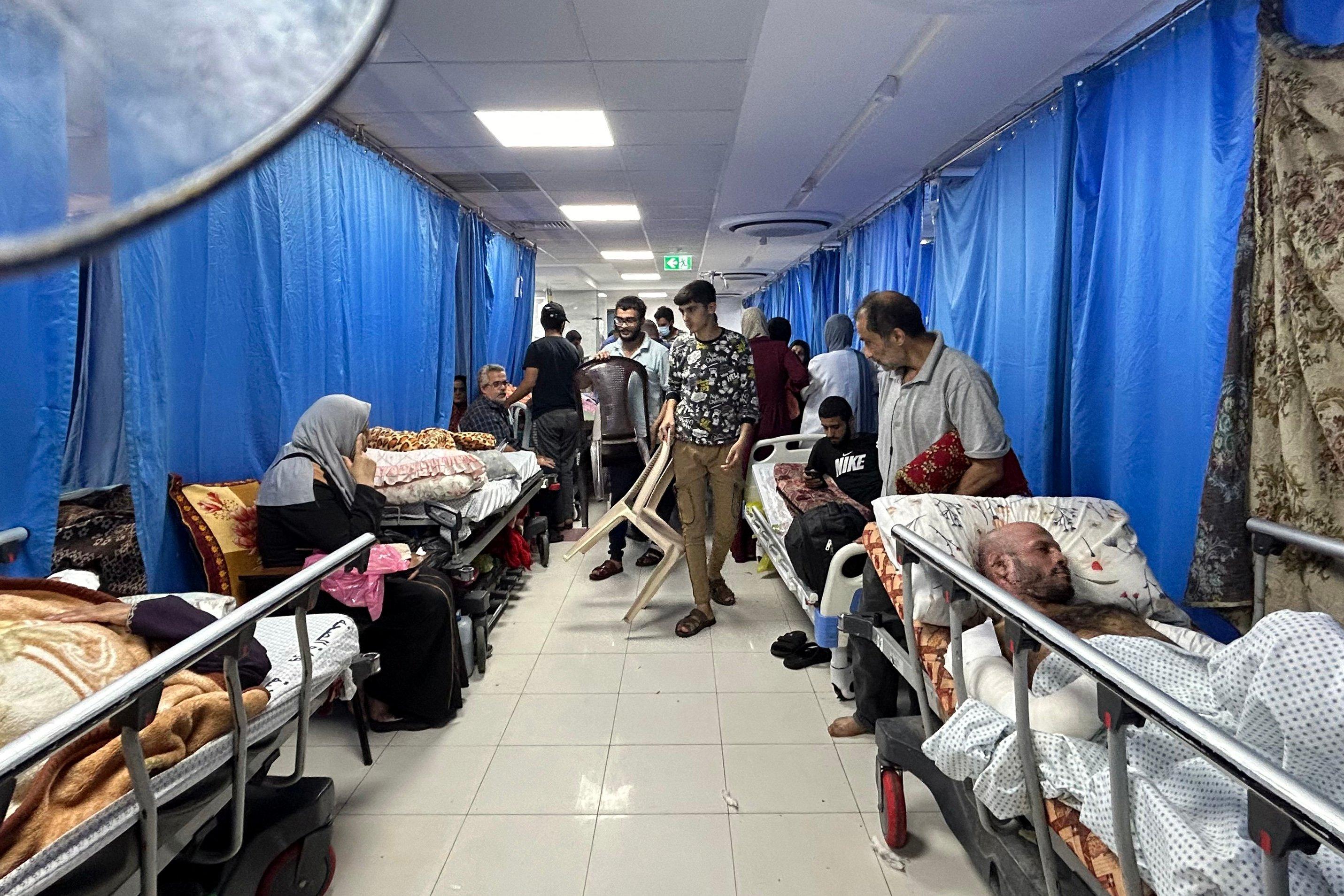 szpitalny korytarz pełen łóżek i ludzi