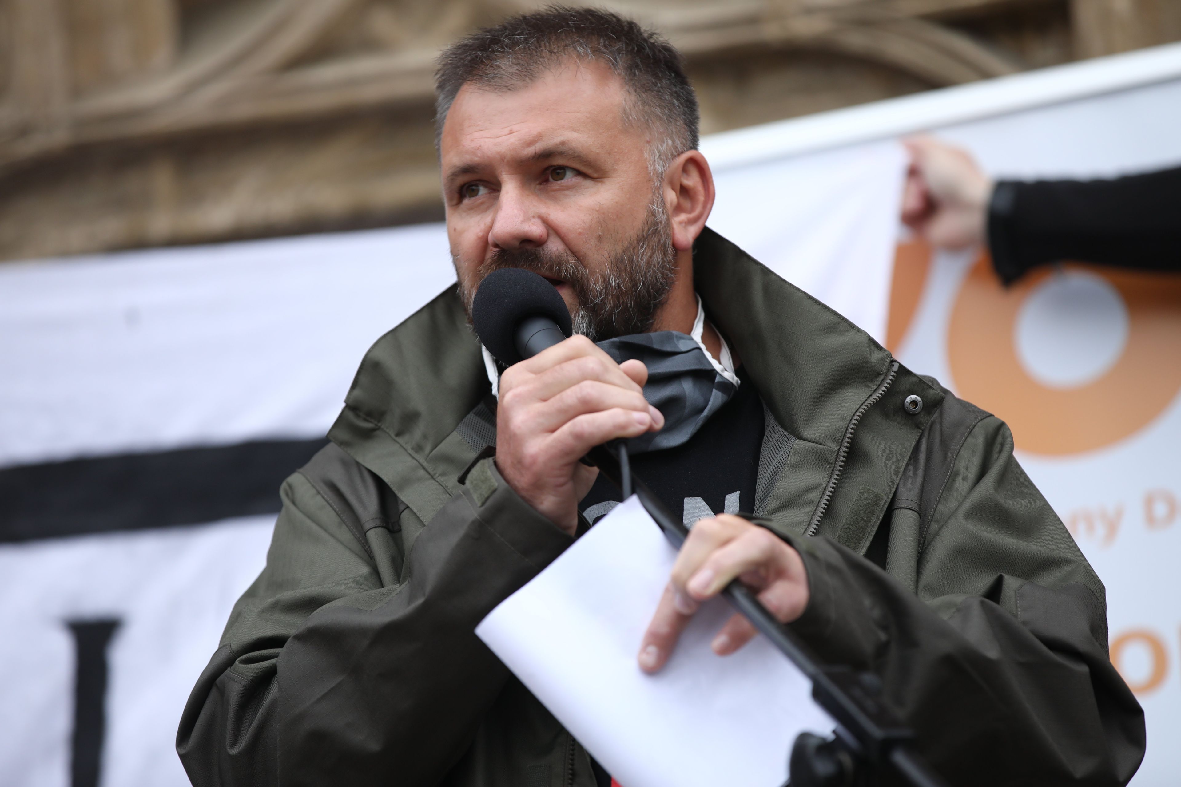 Mężczyzna stoi z mikrofonem w ręku, sędzia Waldemar Żurek