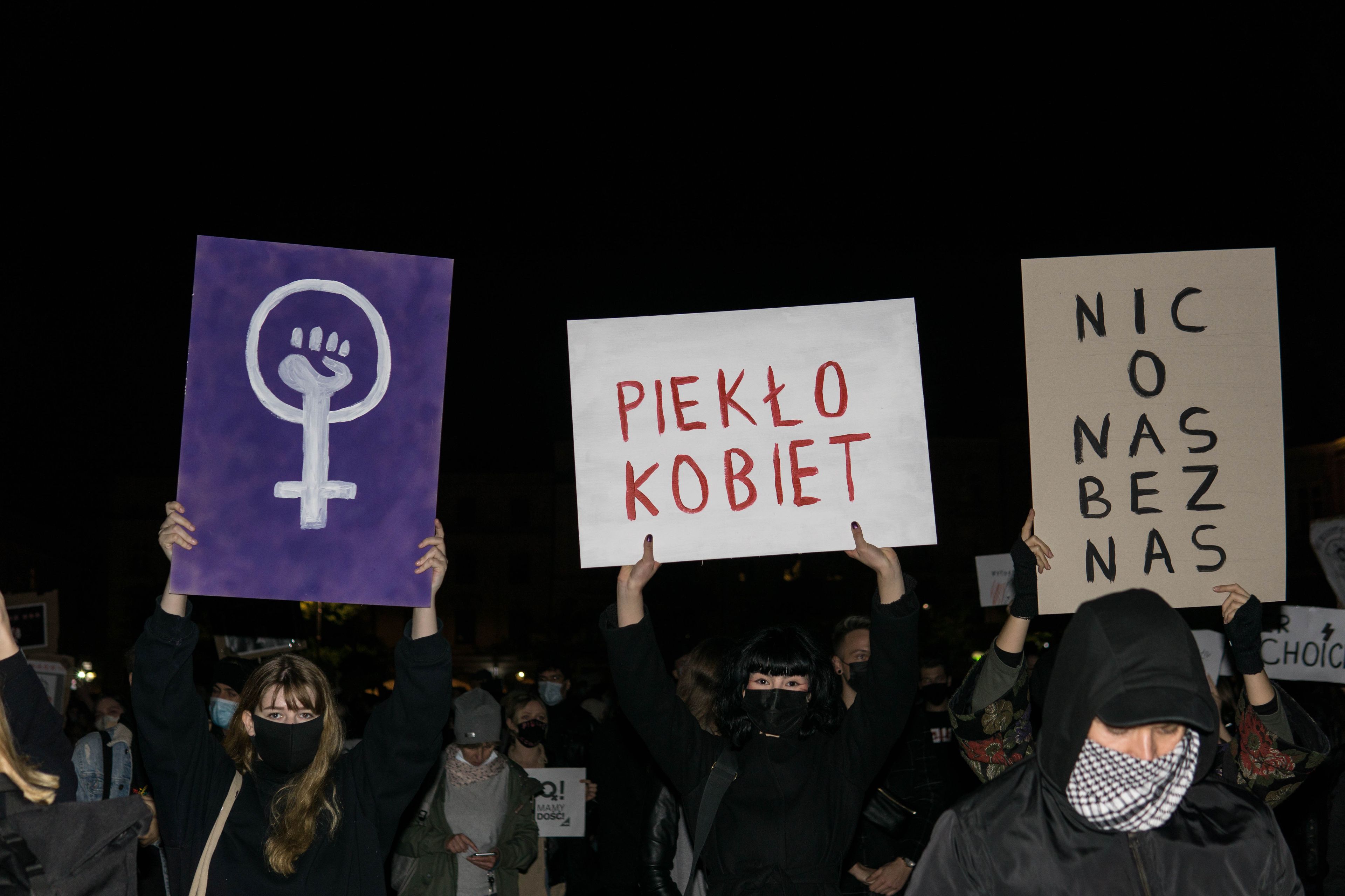 Kobiety trzymają karton z napisem "piekło kobiet"