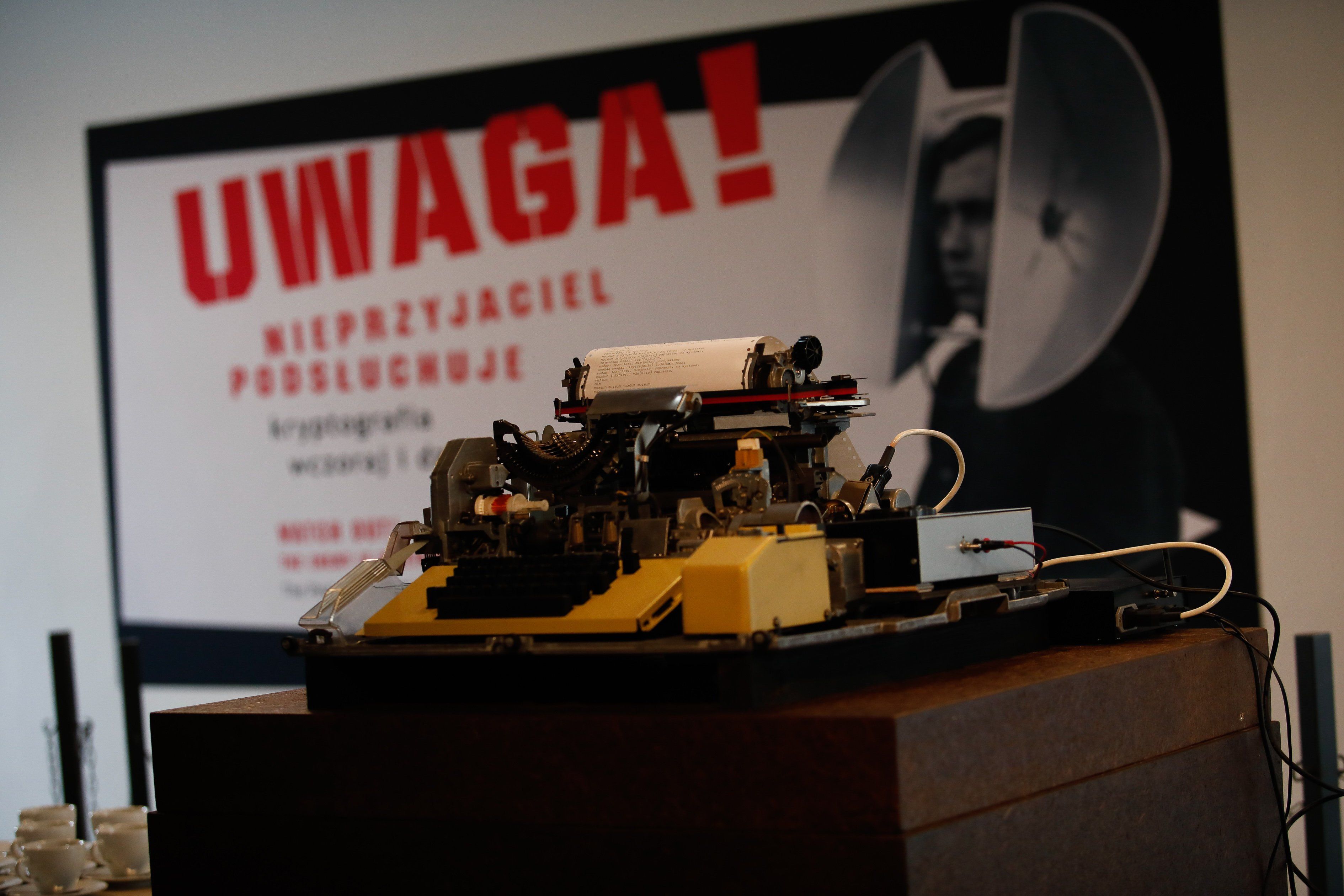 Maszyna szpiegująca i napis "Uwaga! Nieprzyjaciel podsłuchuje".