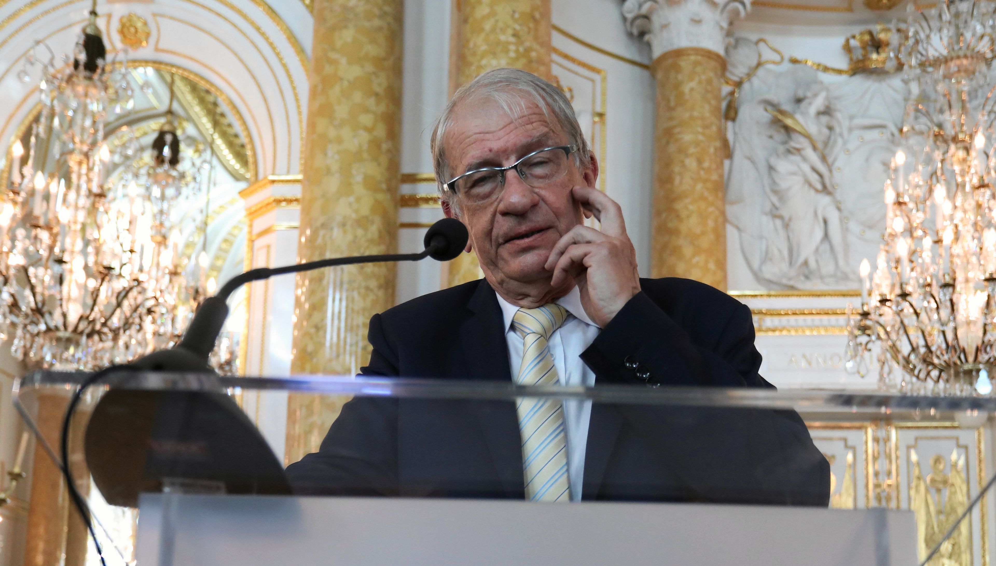 Wojciech Roszkowski stoi na trybunie przed mikrofonem