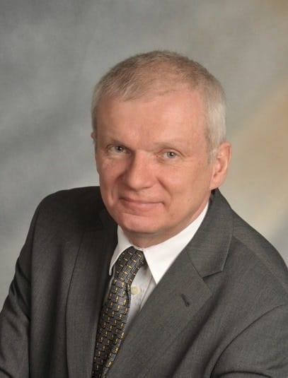 Siwiejący i łysiejący 50-latek w garniturze