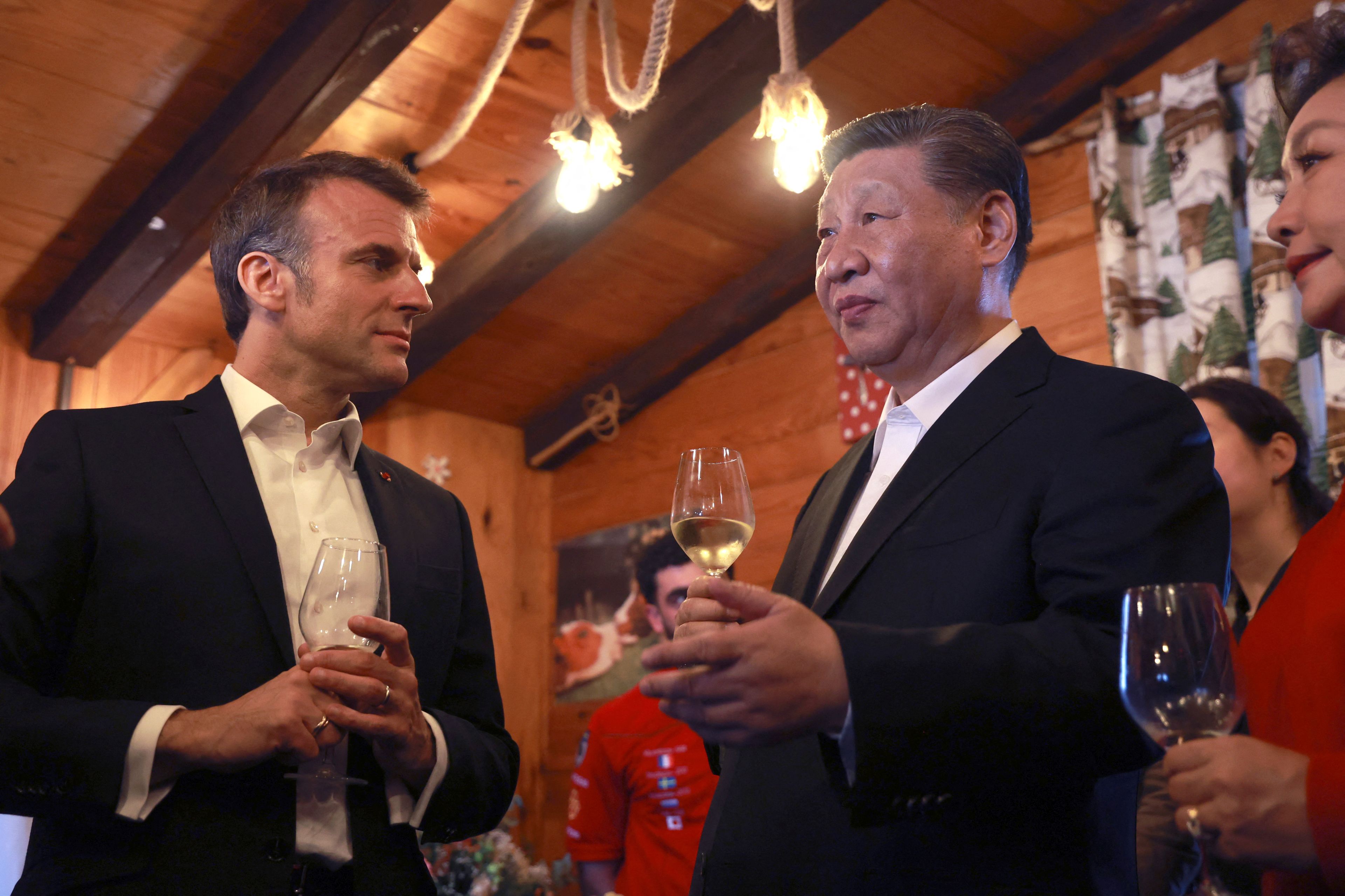 Europejczyk i Azjata w garniturach z kieliszkami koniaku