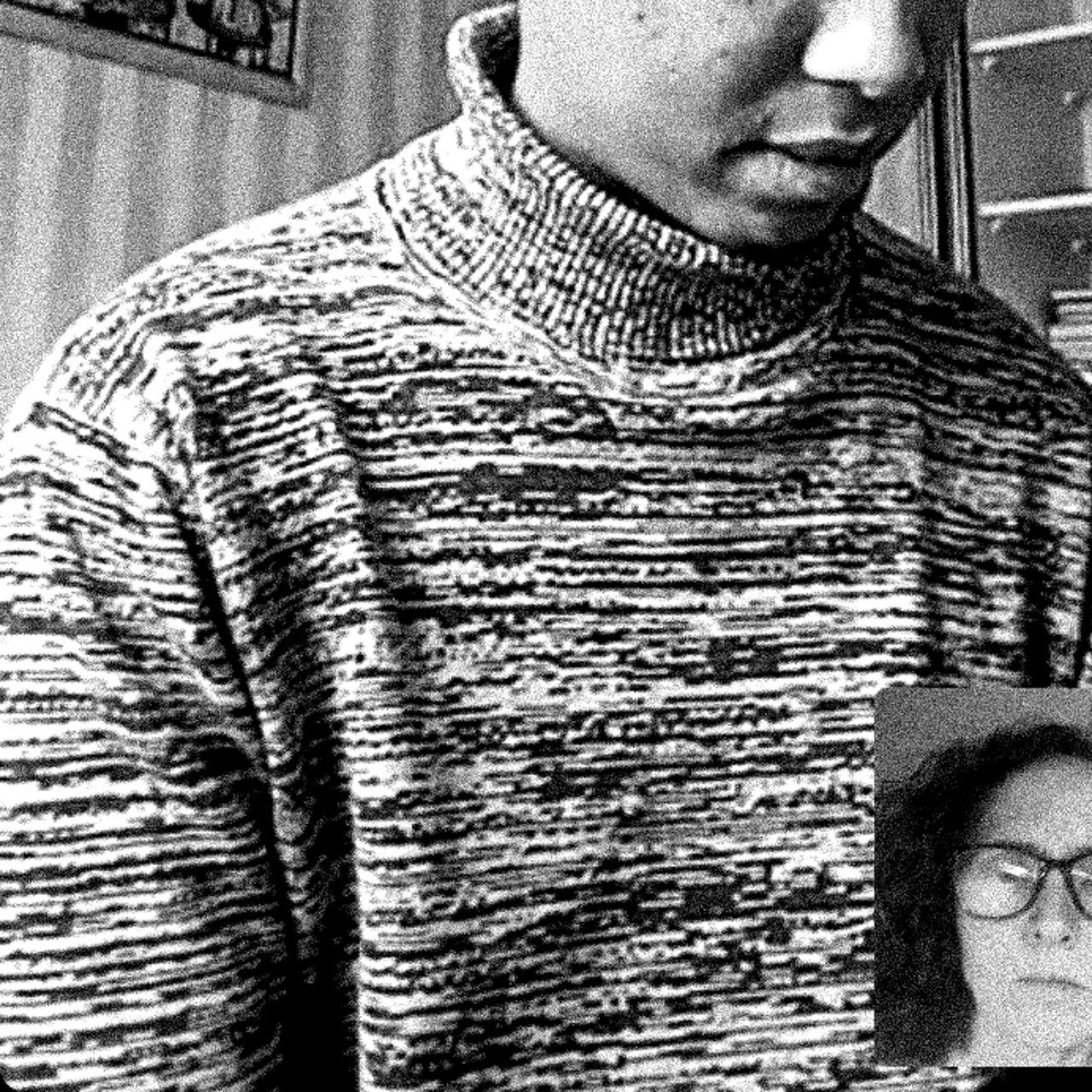 Czarno-białe zdjęcie, portret chłopca w szarym golfie, zdjęcie "obcina" oczy i górną cześć twarzy