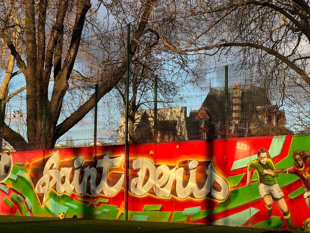 grafitti na płocie z napisem Saint-Denis