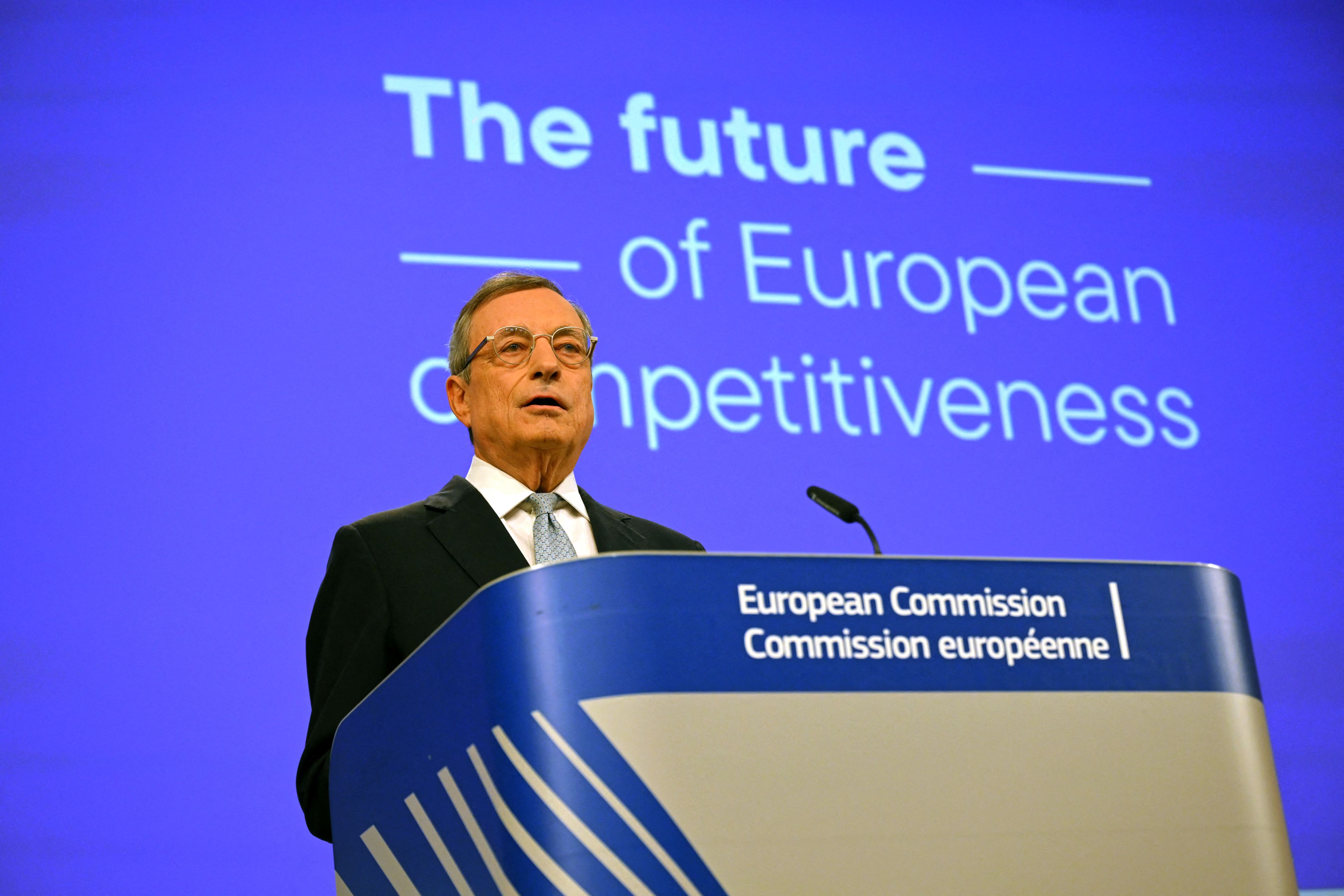 Mario Draghi na niebieskim tle podczas konferencji prasowej