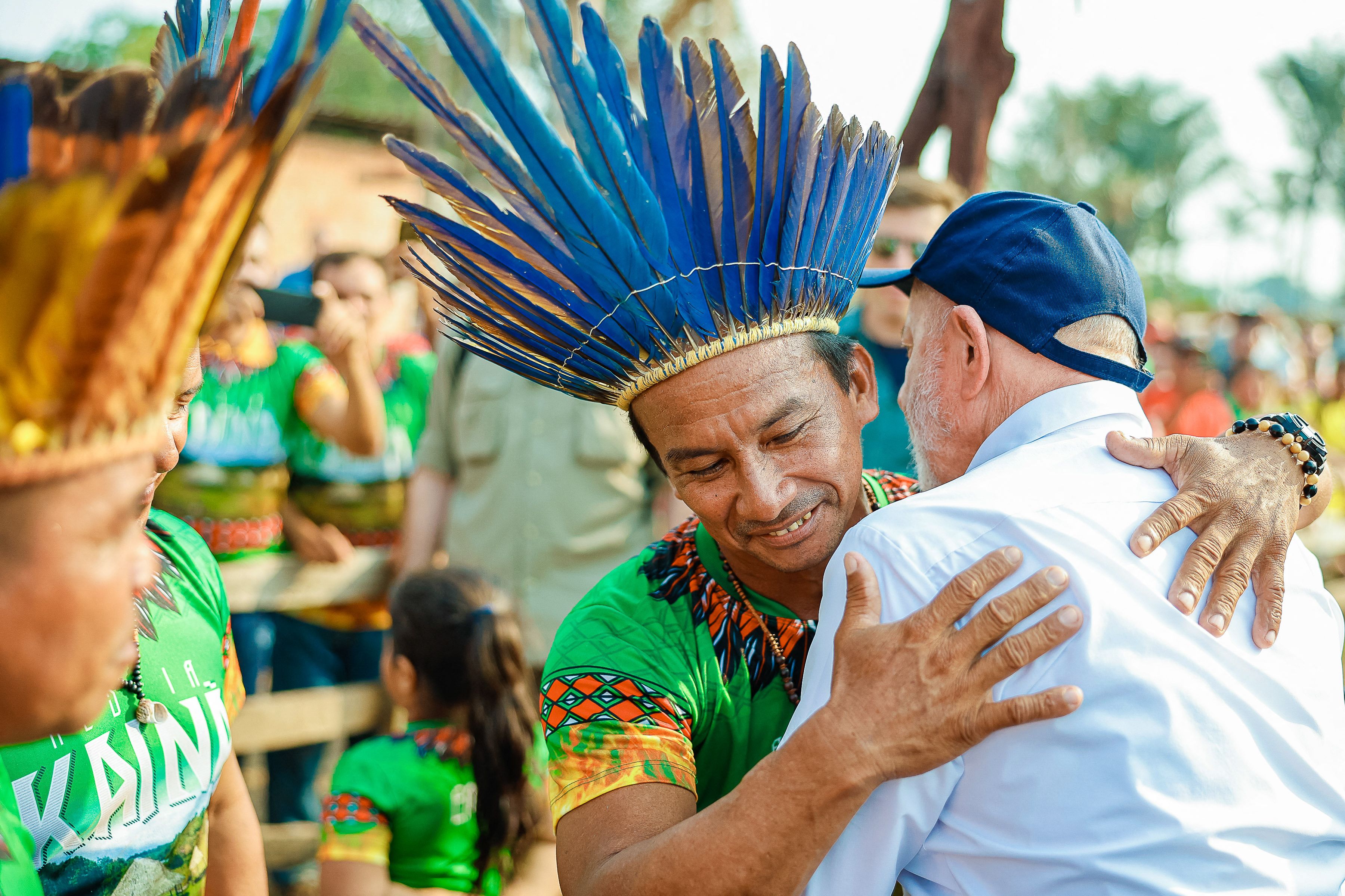 Rdzenny mieszkaniec Ameryki Południowej w pióropuszu obejmuje białego w białej koszuli
