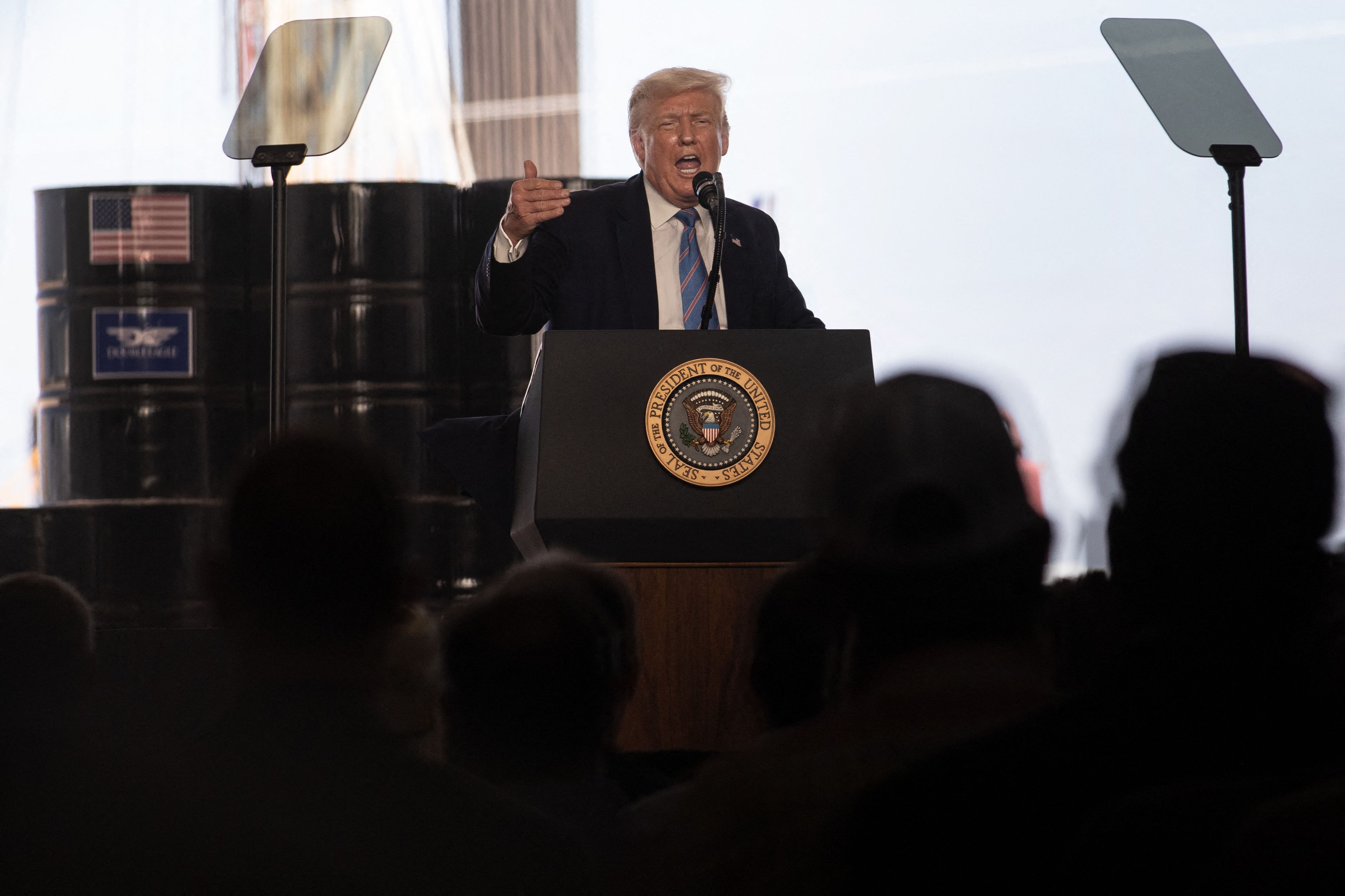 Donald Trum przemawia na tle beczek z ropą