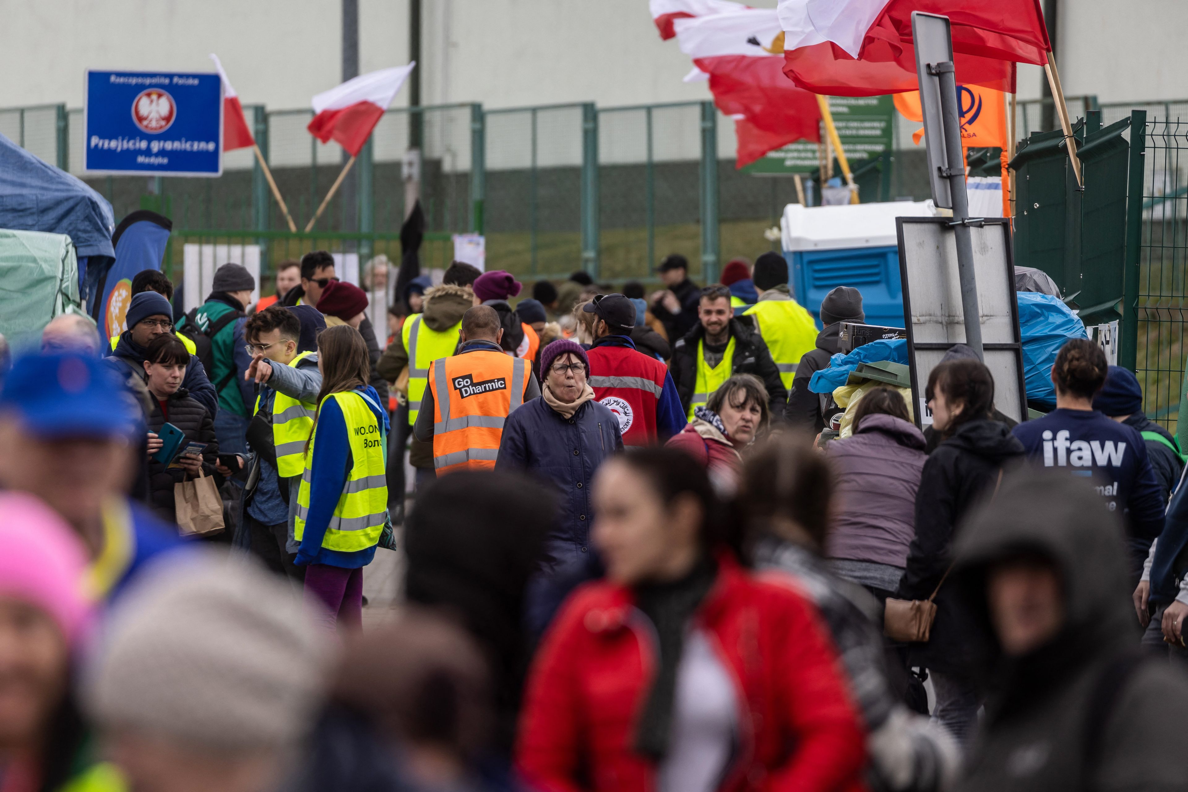 tłumy ludzi na granicy i biało-czerwone flagi