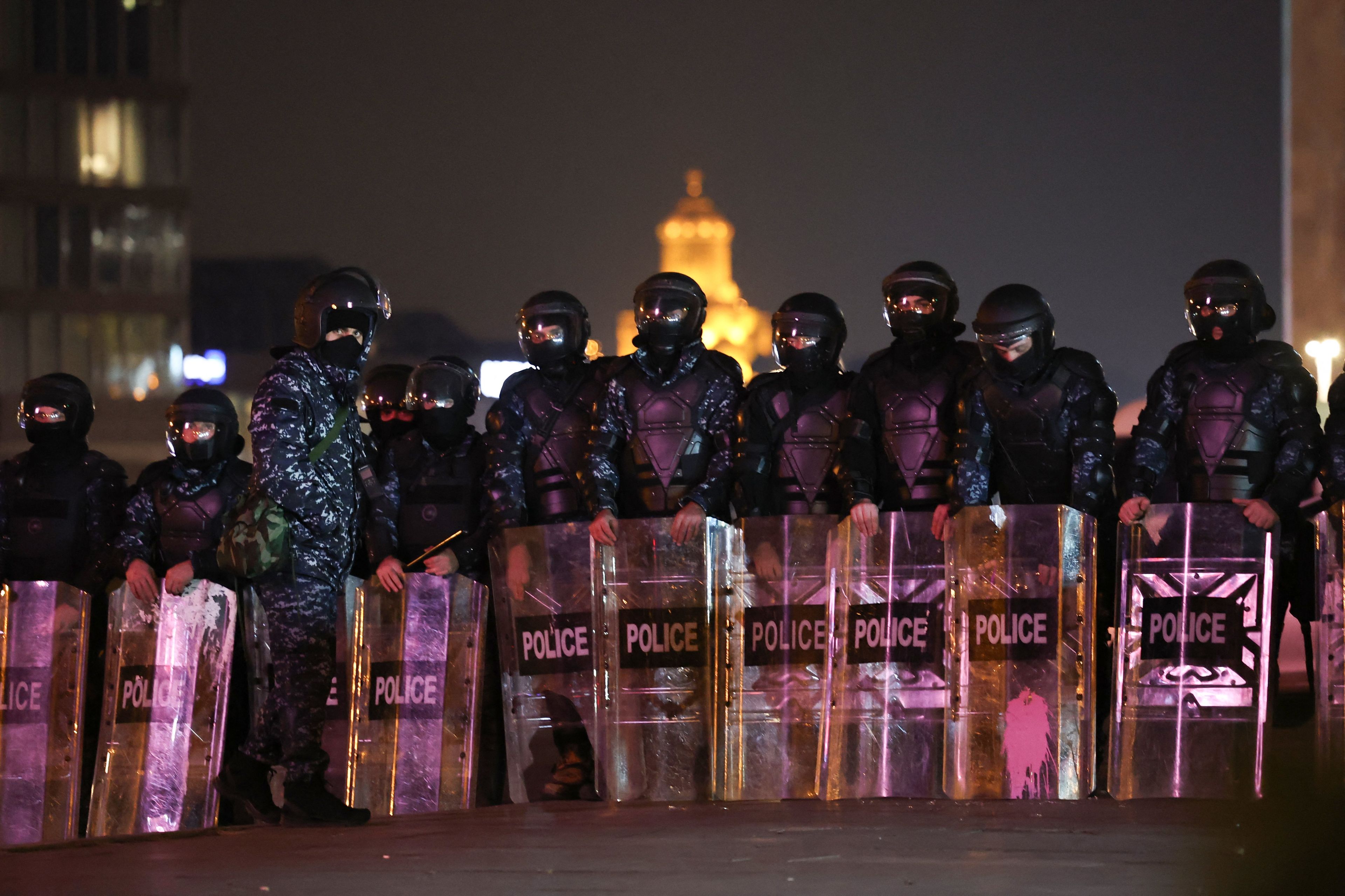 Noc. Rząd zamaskowanych policjantów z tarczami