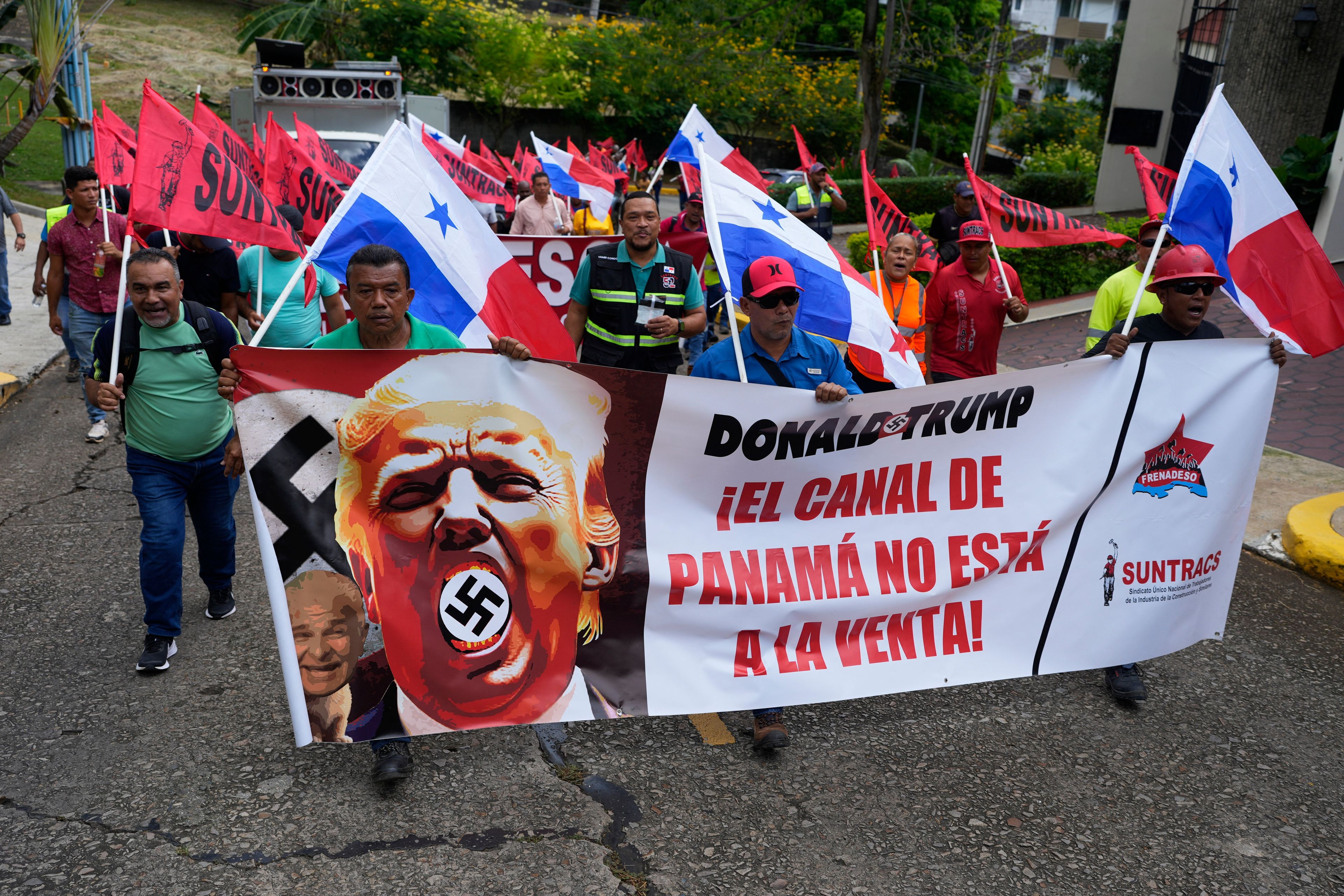 Demonstranci niosą transparent z napisem "Kanał Panamski nie jest na sprzedaż" z wizerunkiem Donalda Trumpa ze swastyką przed siedzibą ambasady USA w Panama City, 20.01.2025 r