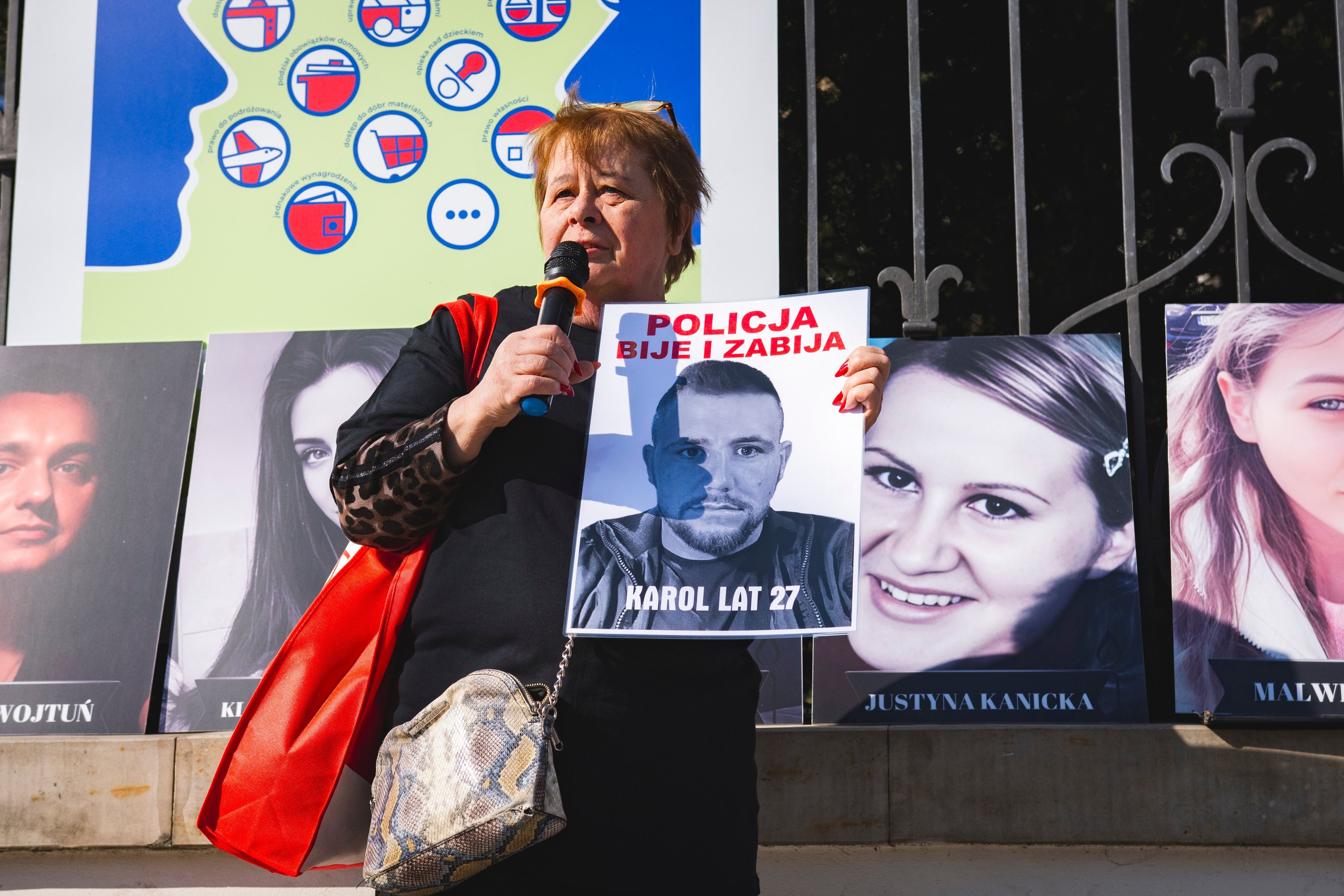 Kobieta trzyma zdjęcie zmarłego. Obok inne portrety