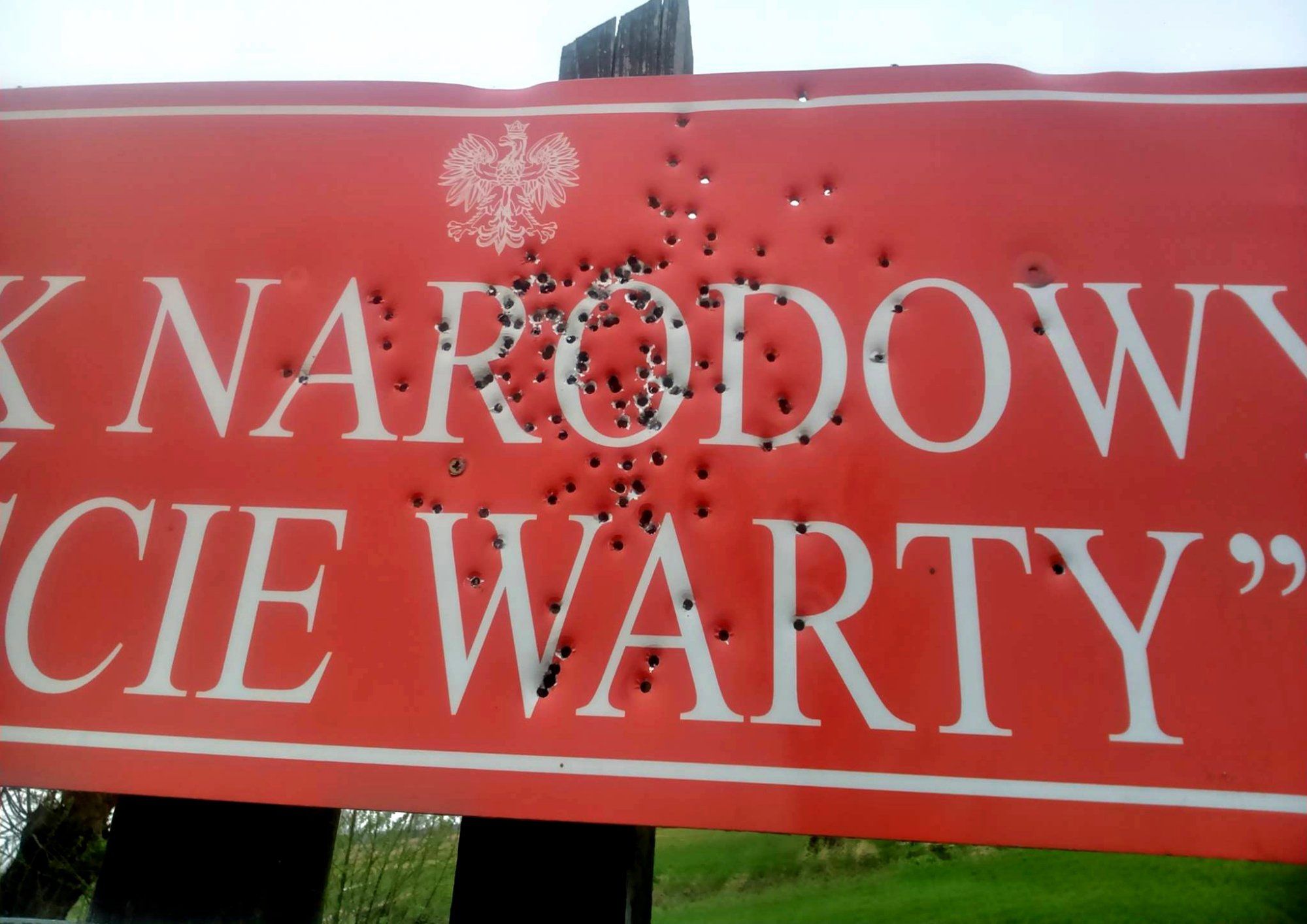 czerwony znak park narodowy ujście warty, cały w dziurach od strzałów
