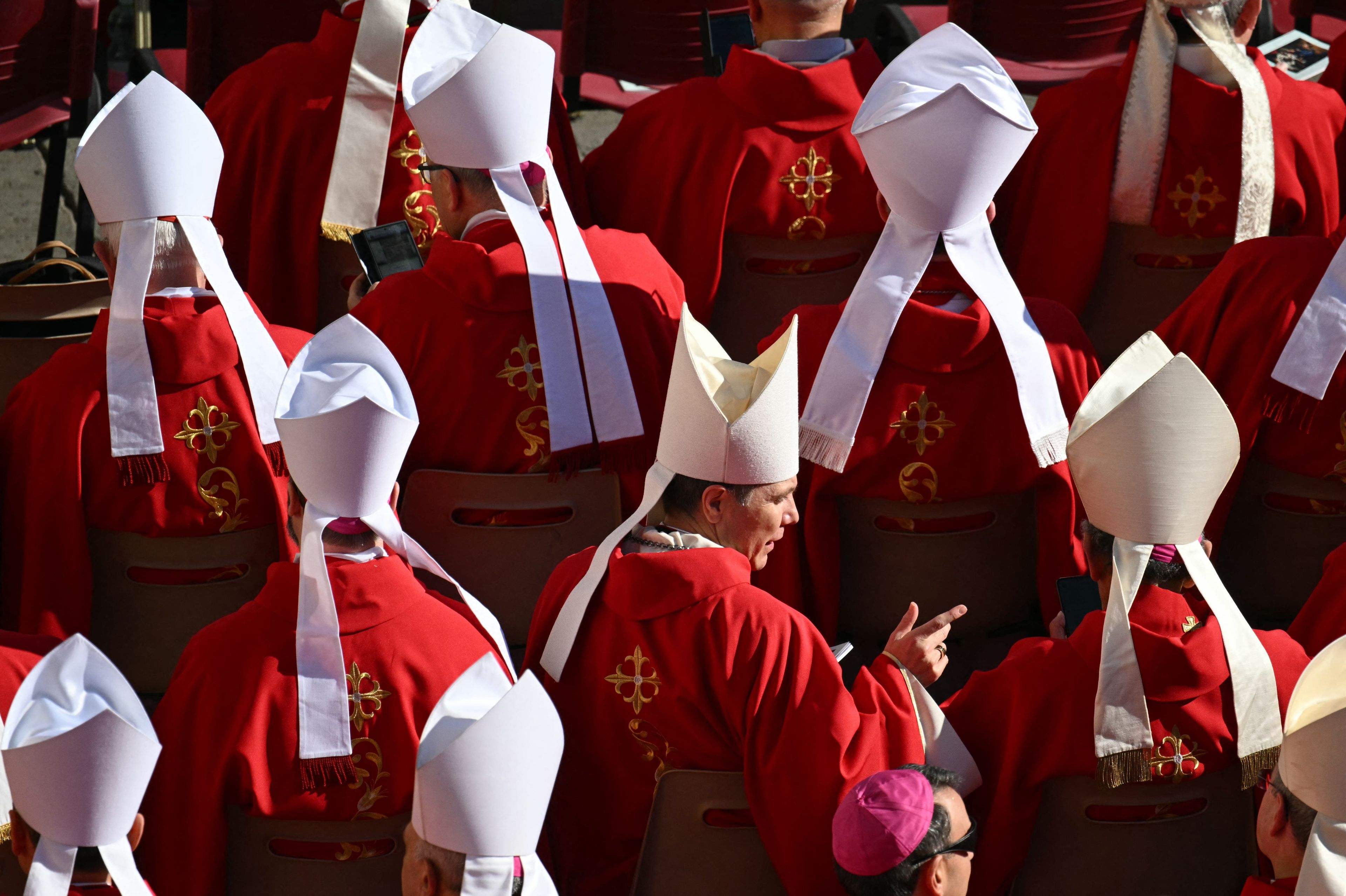 Cardinals speak as they take their places ahead of the late Pope Francis' funeral ceremony at St Peter's Square at The Vatican on April 26, 2025. (Photo by Mandel NGAN / AFP)