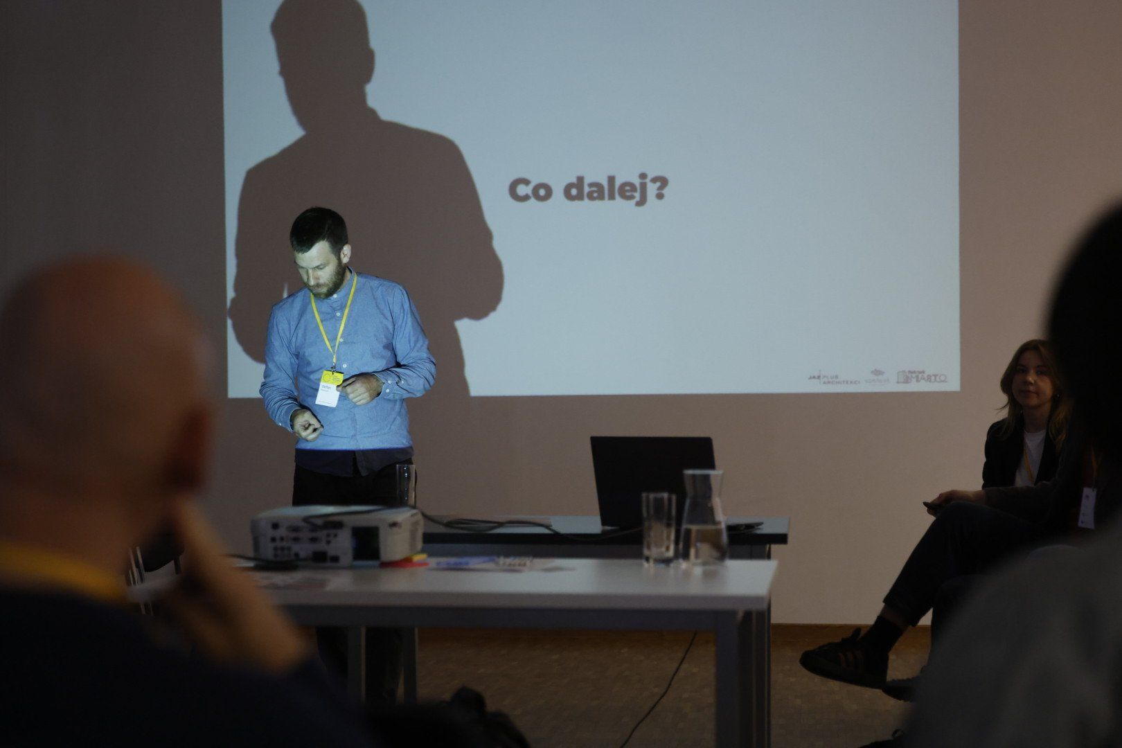 Prezentacja: napis "No i co dalej" i mezczyzna, którego wielki cień pada na ekran