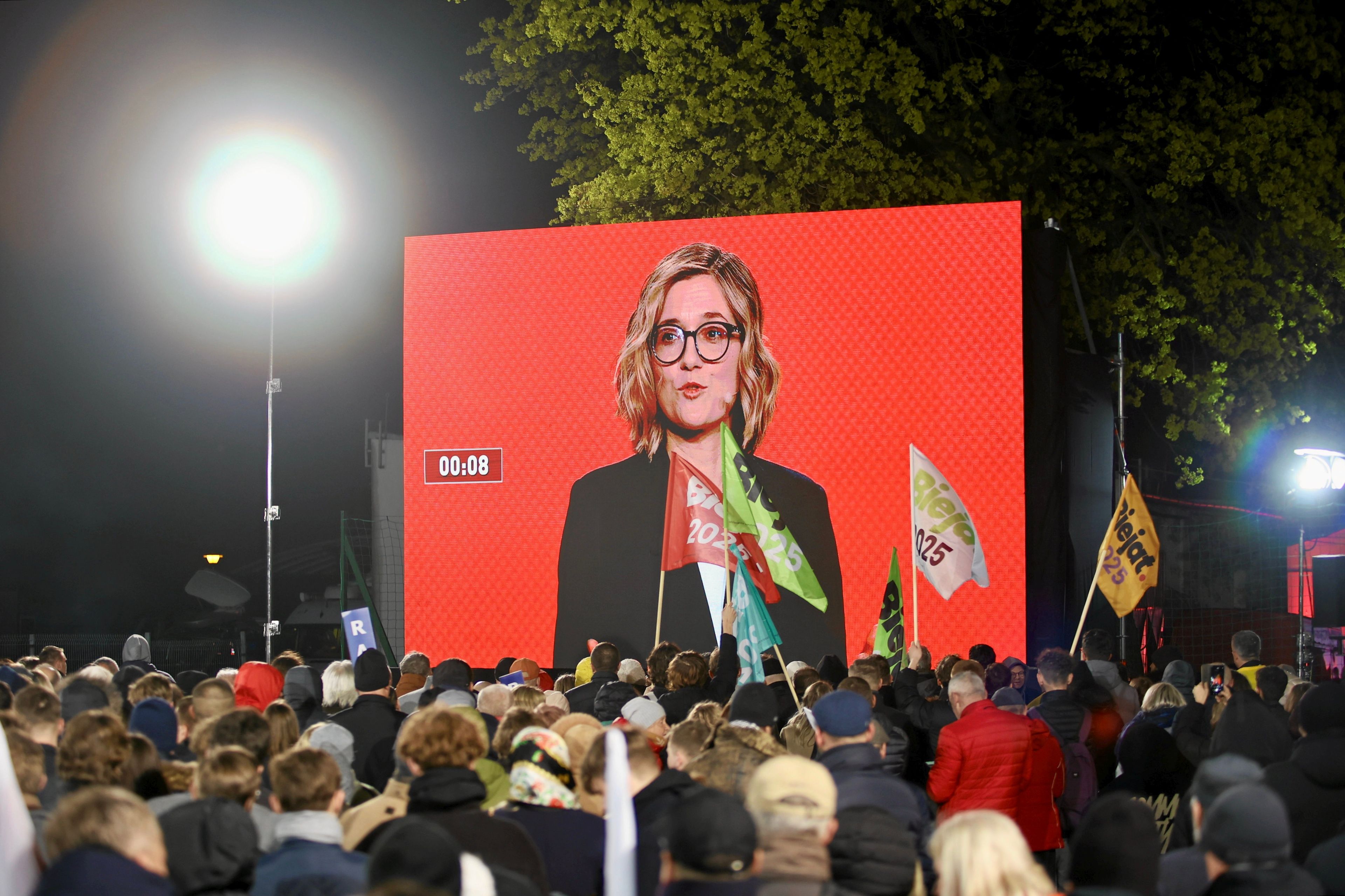 Magdalena BIejat podczas debaty prezydenckiej. Końskie, ludzie na zewnątrz oglądają debatę. Fot. Wojciech Habdas / Agencja Wyborcza.pl
