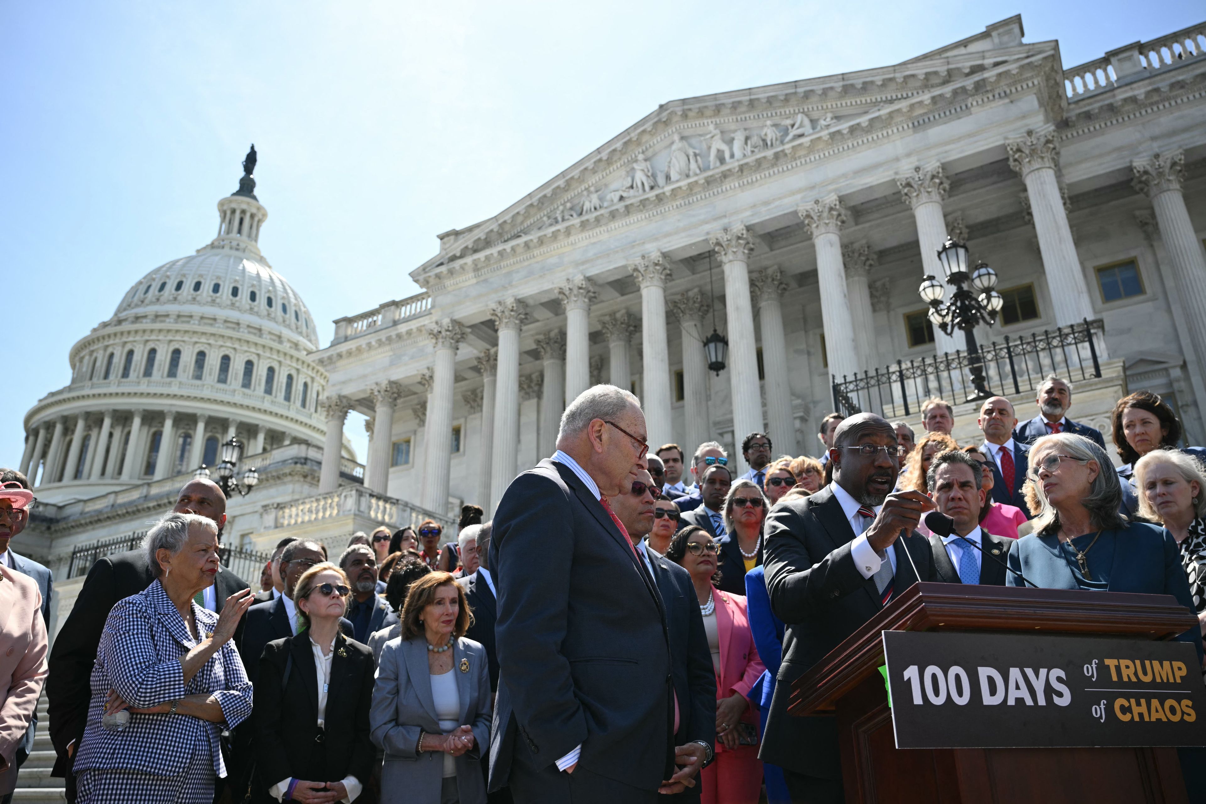 US Senator Raphael Warnock, Democrat from Georgia, with Senate Minority Leader Chuck Schumer (L) Democrat from New York speaks on 100 days of the Trump administration on the Senate Steps of the US Capitol in Washington, DC on April 30, 2025. (Photo by Mandel NGAN / AFP)