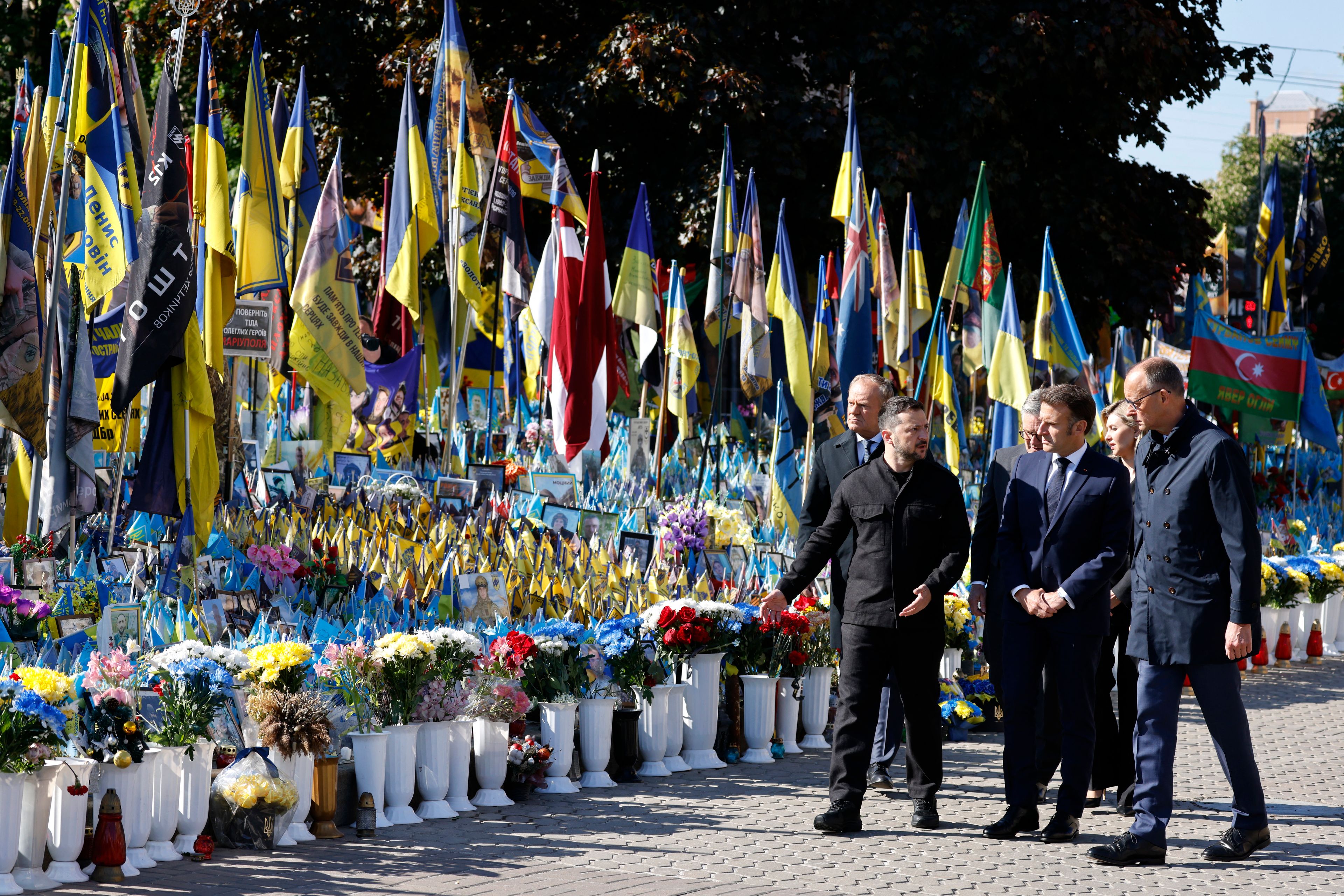 (From L) Poland's Prime Minister Donald Tusk, Ukraine's President Volodymyr Zelensky, Britain's Prime Minister Keir Starmer, France's President Emmanuel Macron, Olena Zelenska and Germany's Chancellor Friedrich Merz pay their respects to the victims of war at the  Memorial for the Fallen at the Independence Square (Maidan) in Kyiv on May 10, 2025, ahead of a gathering of European leaders in the Ukranian capital. The leaders of Britain, France, Germany and Poland make an unprecedented joint visit to Kyiv on May 10, 2025 for talks with Ukraine's President Volodymyr and to urge Russia to agree a ceasefire, a joint statement said. (Photo by Ludovic MARIN / POOL / AFP)