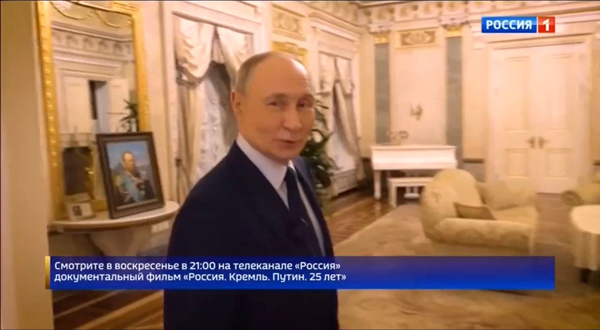 Łysu starszy męzczyzna (Putin) w biało0złotym salonie, w tle - biały fortepian