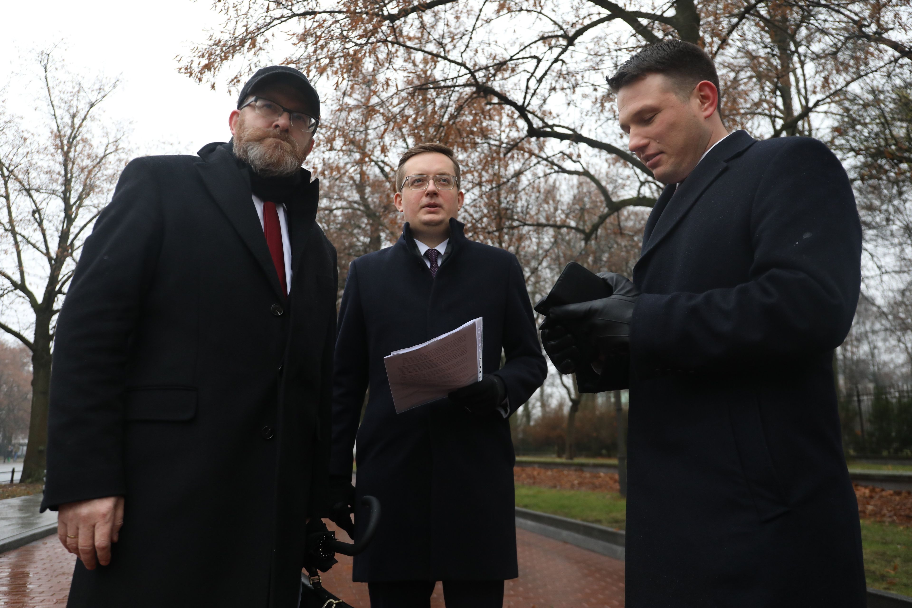 Trzech mężczyzn w zimowych płąszczach