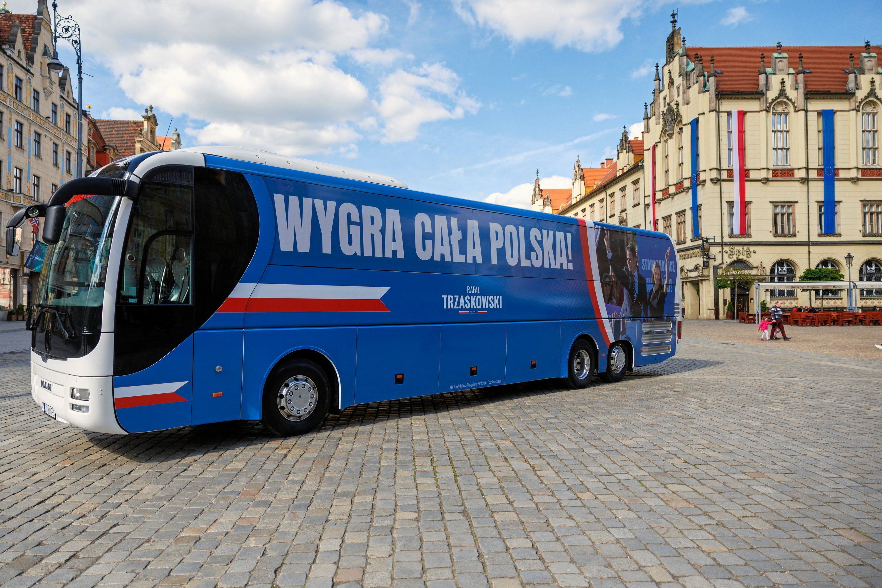 Niebieski autobus z napisem „Wygra cała Polska".