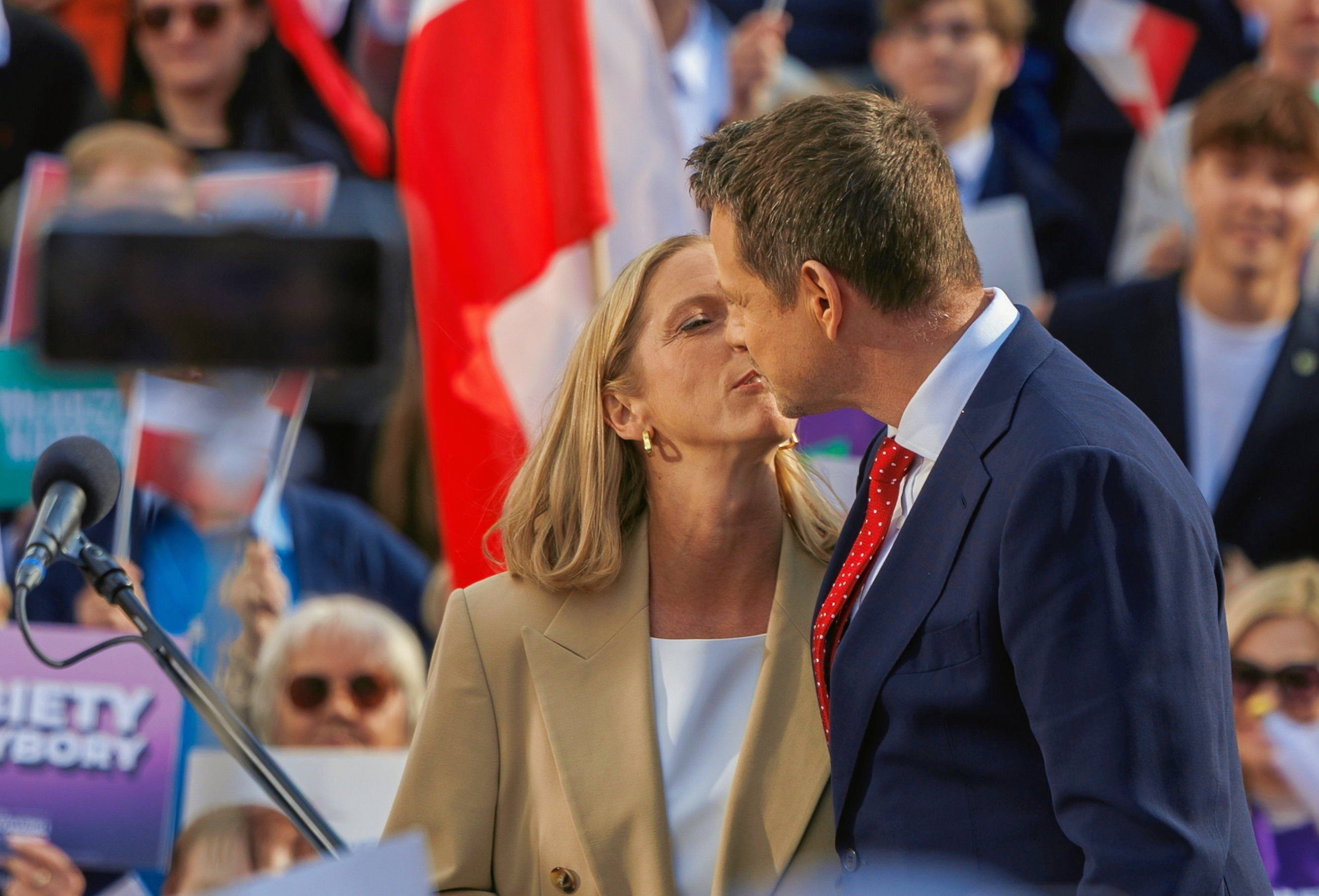 Pocałunek mężczyzny w czerwonym krawacie i kobiety w jasnym żakiecie