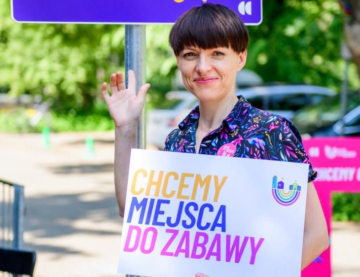 kobieta trzyma napis CHCEMY MIEJSCA DO ZABAWY