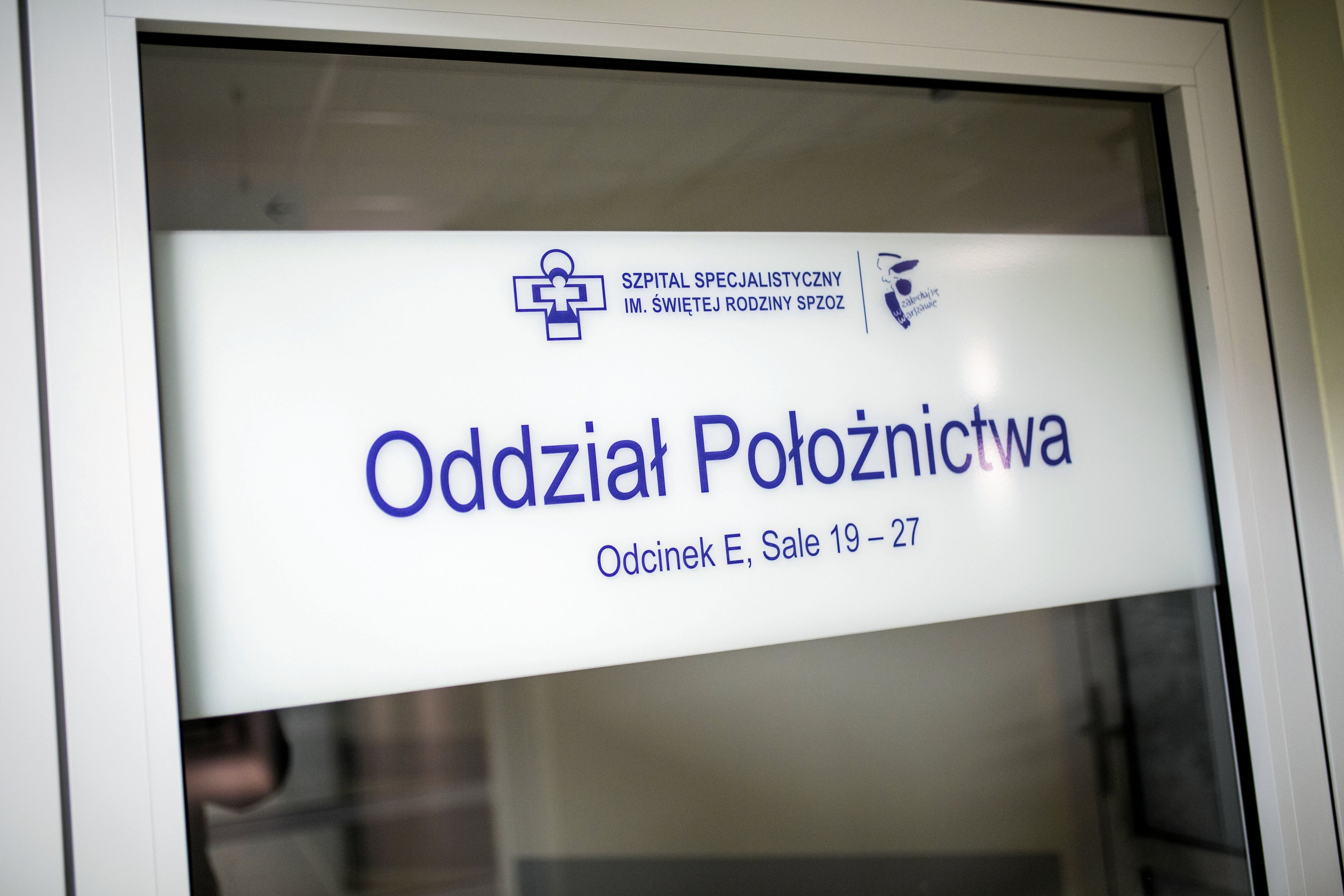 Szklane drzwi z tabliczką z napisem Odział Położnictwa