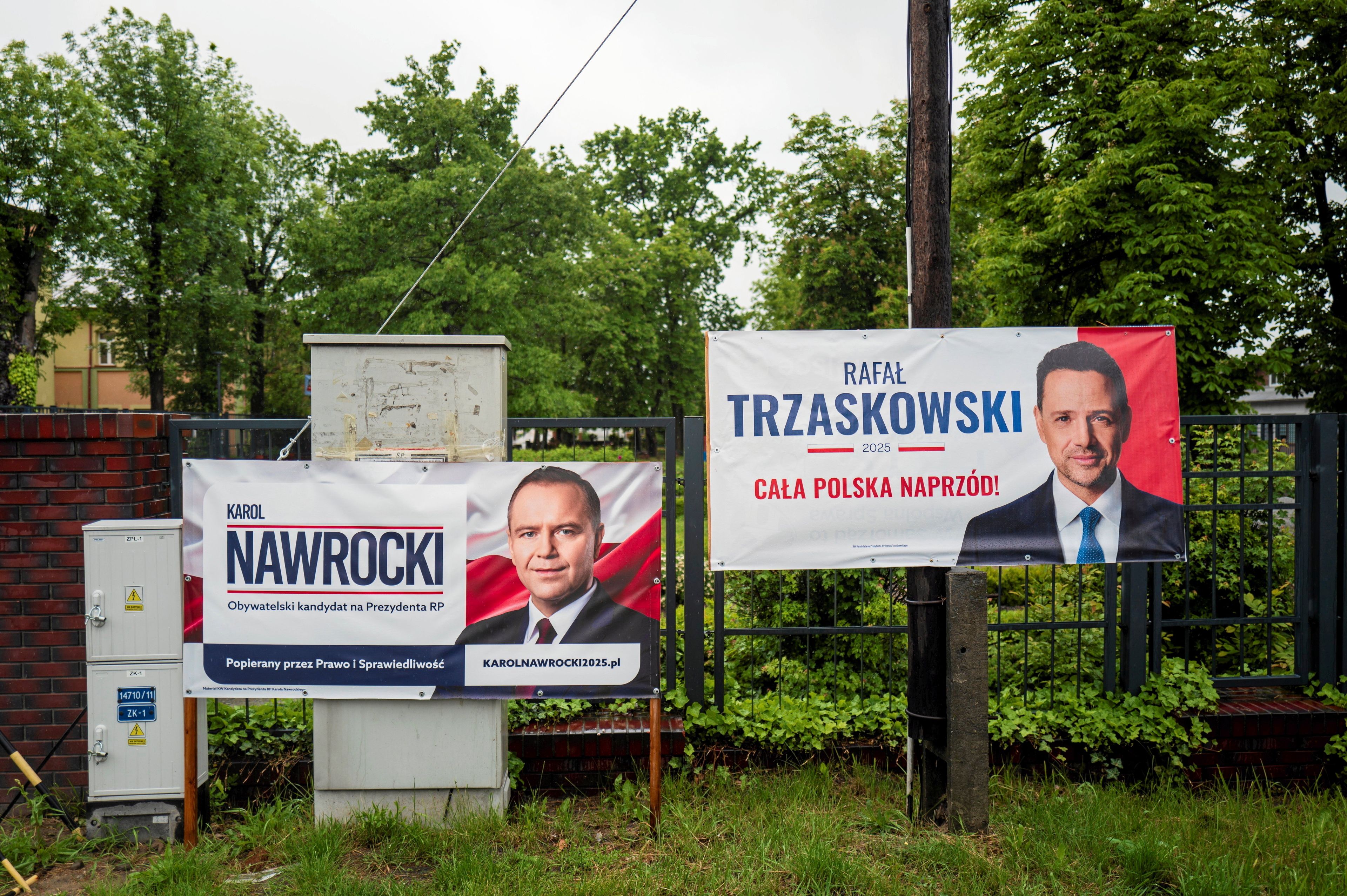 Ulica w mieście, na płocie banery wyborcze obu kandydatów