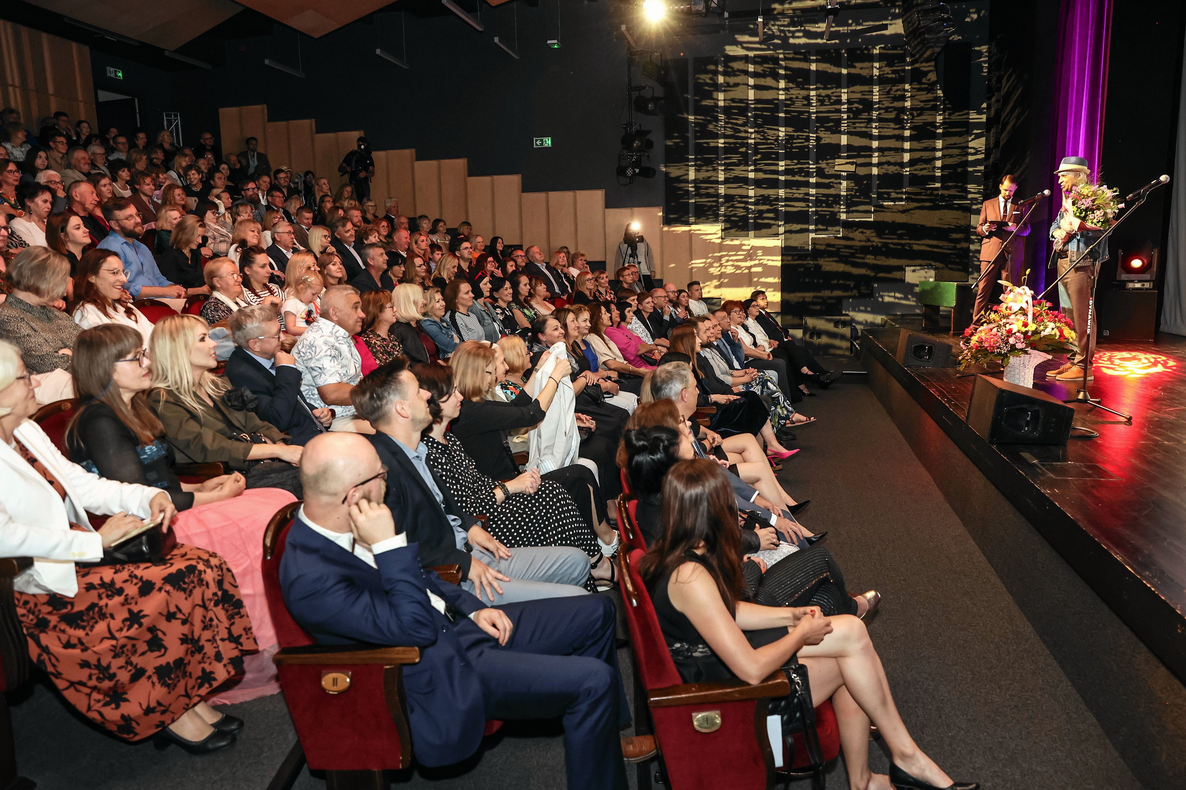 Spektakl w Teatrze im. Żeromskiego w Kielcach. Widać scenę i publiczność z bocznej perspektywy