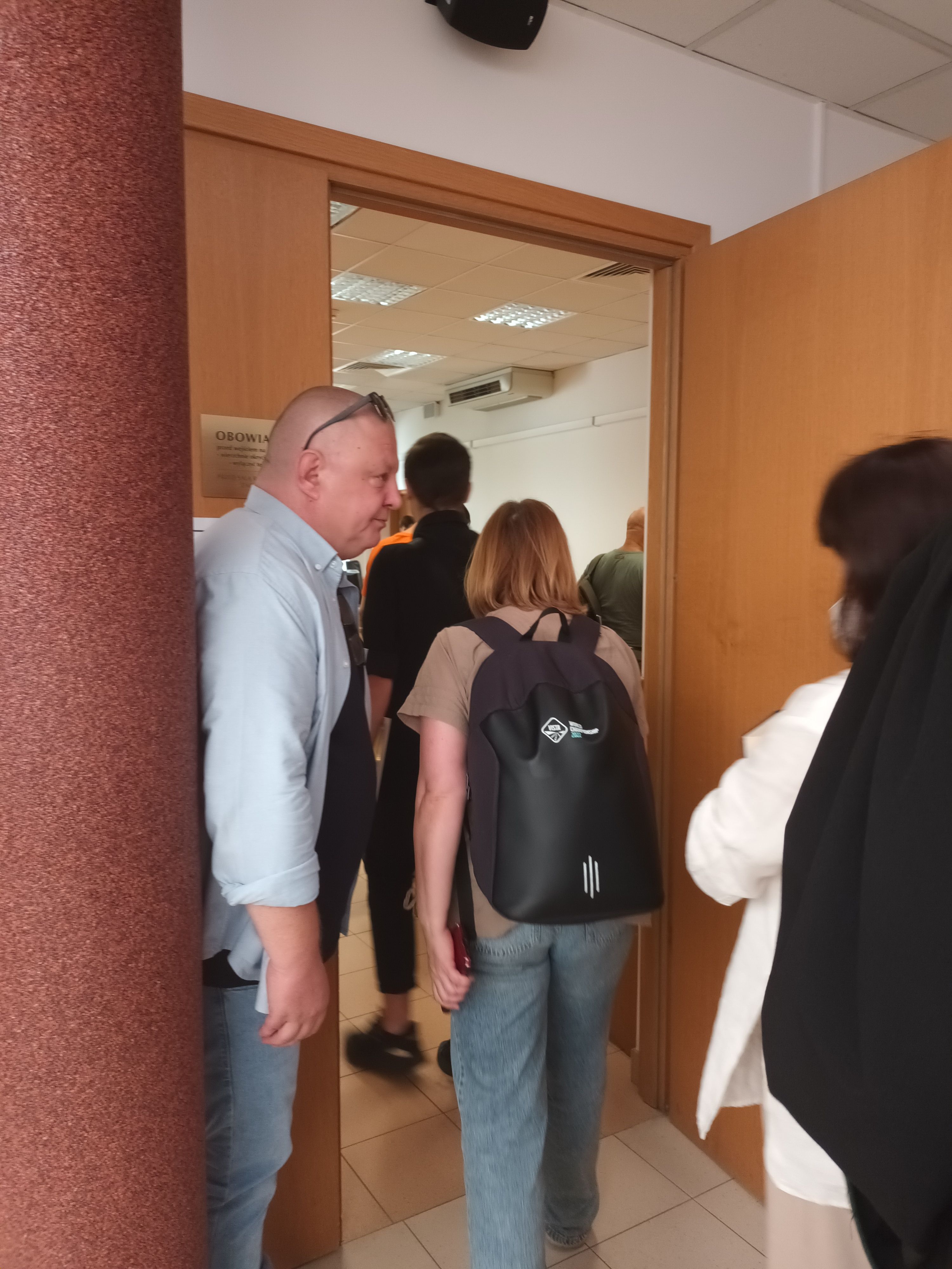 Ludzie wchodzą na salę sądową