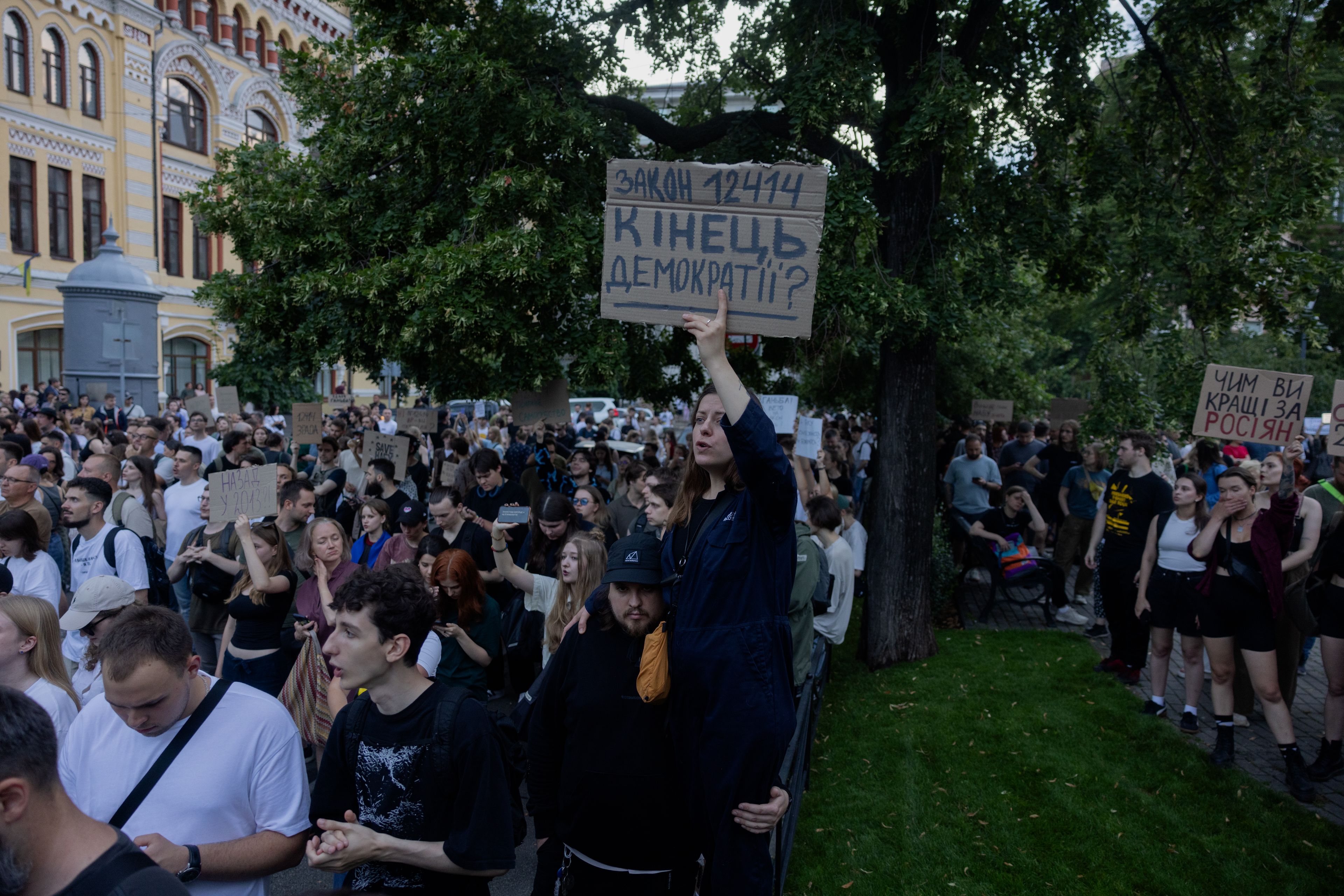 Protesters hold placards during a demonstration calling for the Ukrainian president to veto a law passed by parliament that reduces the powers of Ukraines National Anti-Corruption Bureau (NABU) and Specialised Anti-Corruption Prosecutor's Office (SAPO) in downtown Kyiv on July 22, 2025, amid the Russian invasion of Ukraine. Ukraine's parliament voted on July 22 to revoke the autonomy of the two anti-corruption agencies, a move that critics say will allow government meddling in high-profile graft cases. (Photo by Tetiana DZHAFAROVA / AFP)