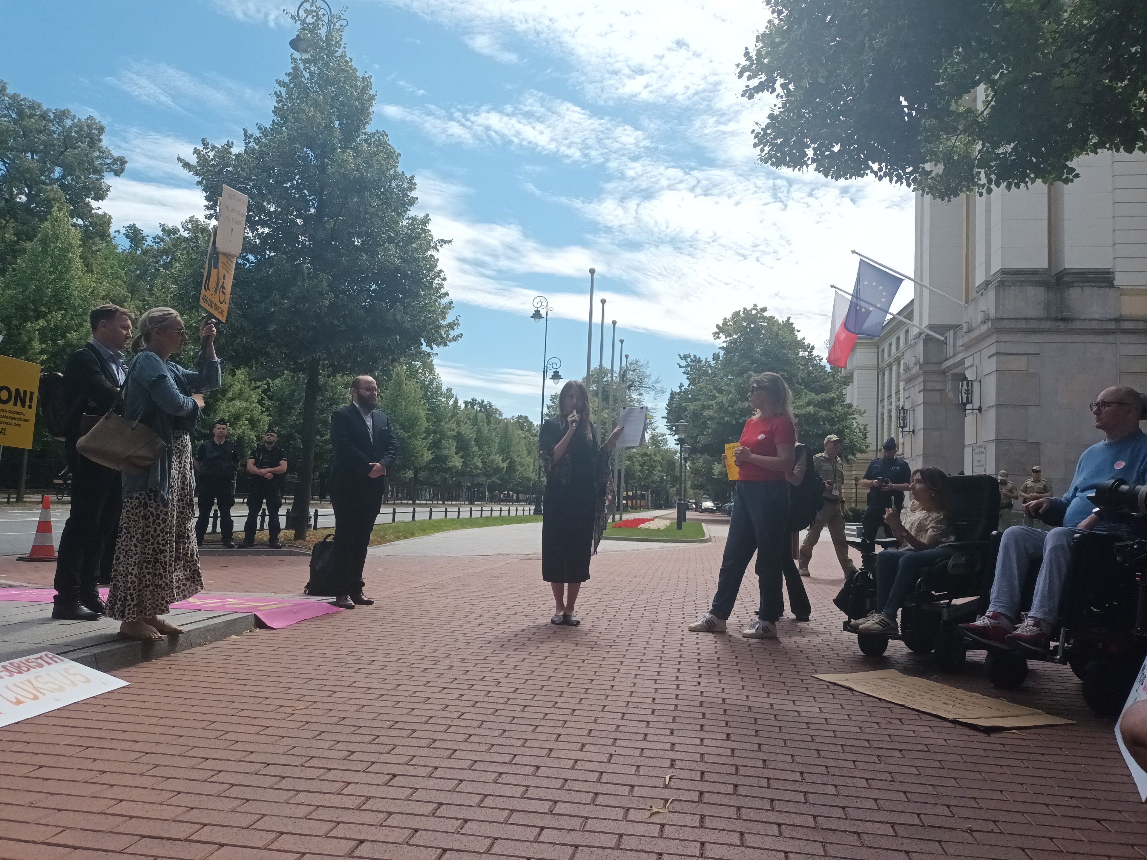 Kobieta przemawia na demonstracji przed KPRM