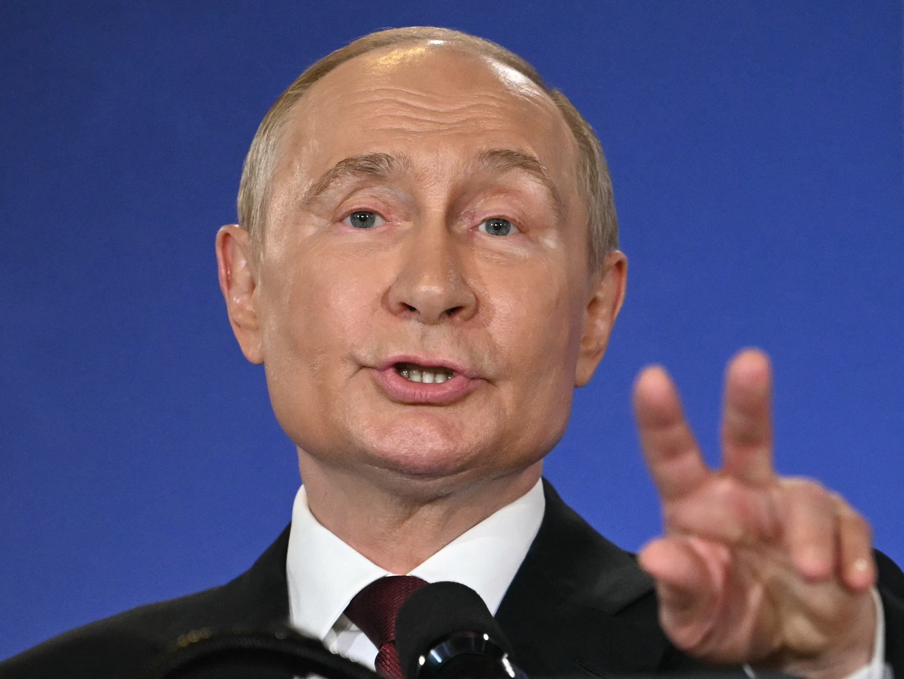 Putin gestykuluje. Jego ręka jest ustawiona prawie w znak zwycięstwa - V, ale nie do końca