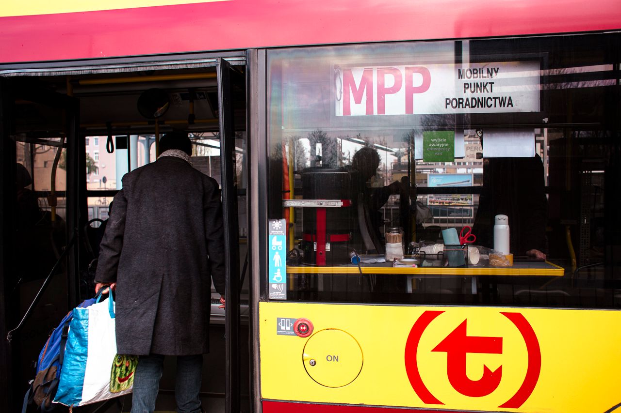 Autobus miejski z napisem MPP. Wchodzi d niego mężczyzna w ciepłym płaszczu.