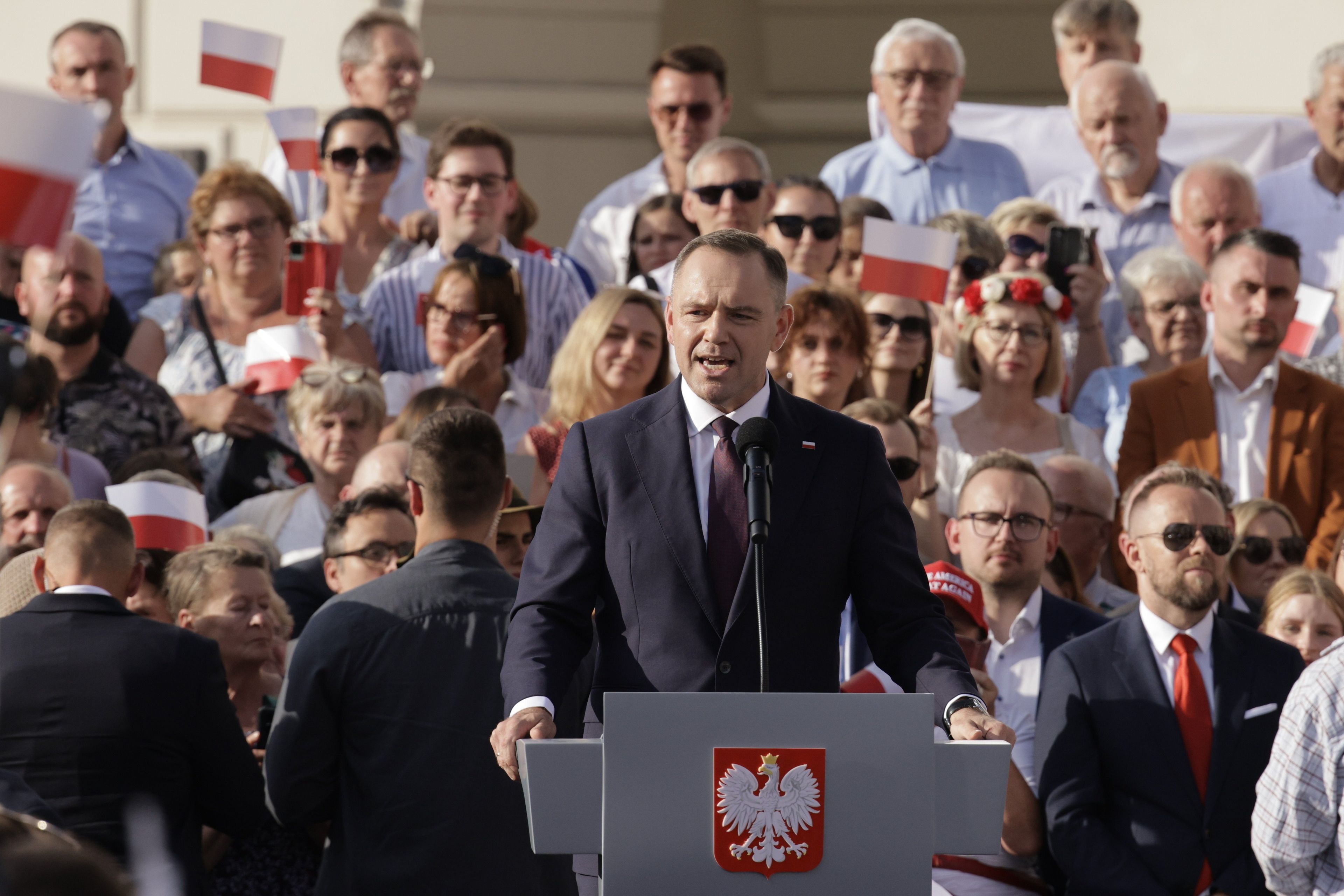 Prezydent Karol Nawrocki przemawia za pulpitem, w tle tłum