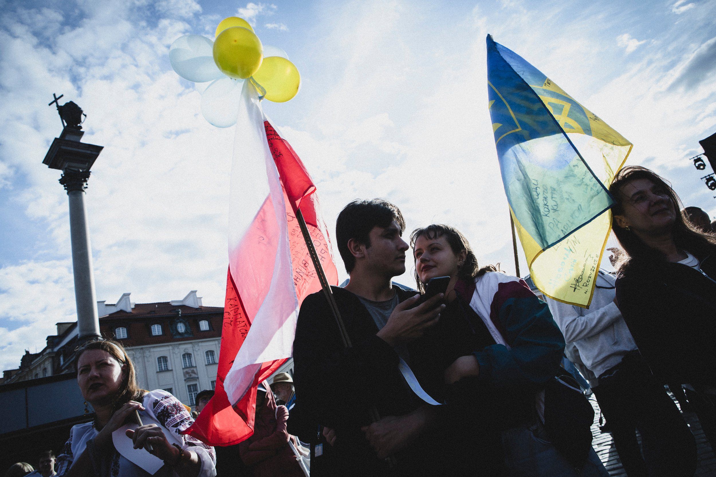 Warszawa 24.08.2025 r. Na Placu Zamkowych w Warszawie kilka tysięcy Ukrainek i Ukraińców oraz Polaków obchodziło Dzień Niepodległości Ukrainy. Na wielkim telebimie puszczone było przemówienie Prezydenta Ukrainy Zełeńskiego. W trakcie minuty ciszy, uczestniczy zgromadzenia trzymali kartki z imionami i nazwiskami poległych w Ukrainie.