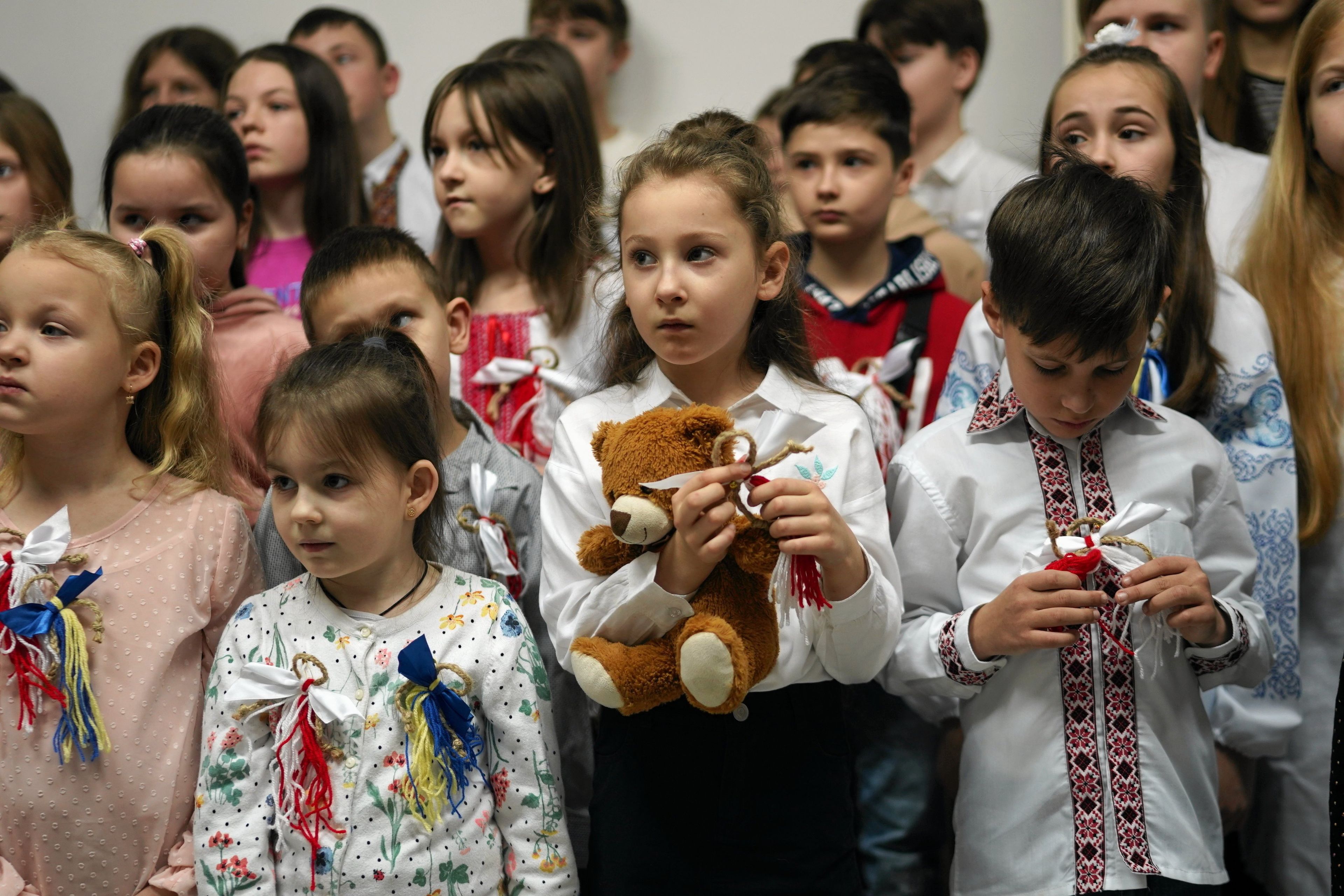 Dzieci w wyszywankach i z wstążeczkami w kolorach flagi polskiej i ukraińskiej.
