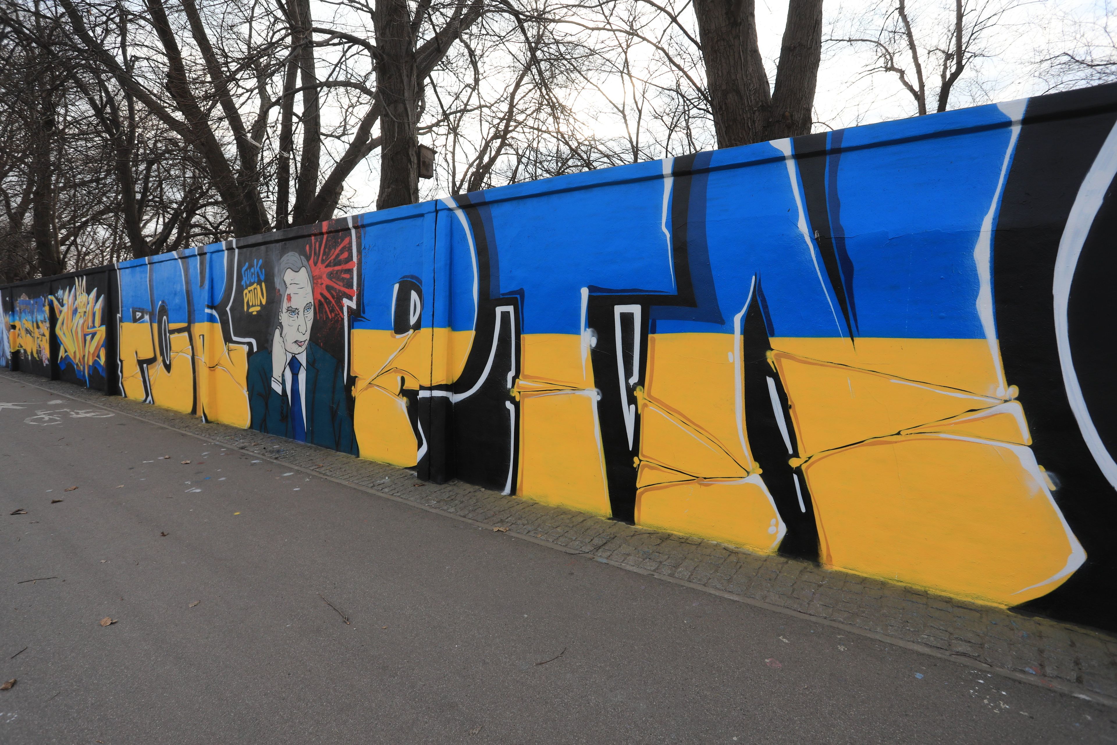 Na zdjęciu jest mur, na którym wiadać grafitti o niebiesko-żółtych kolorach