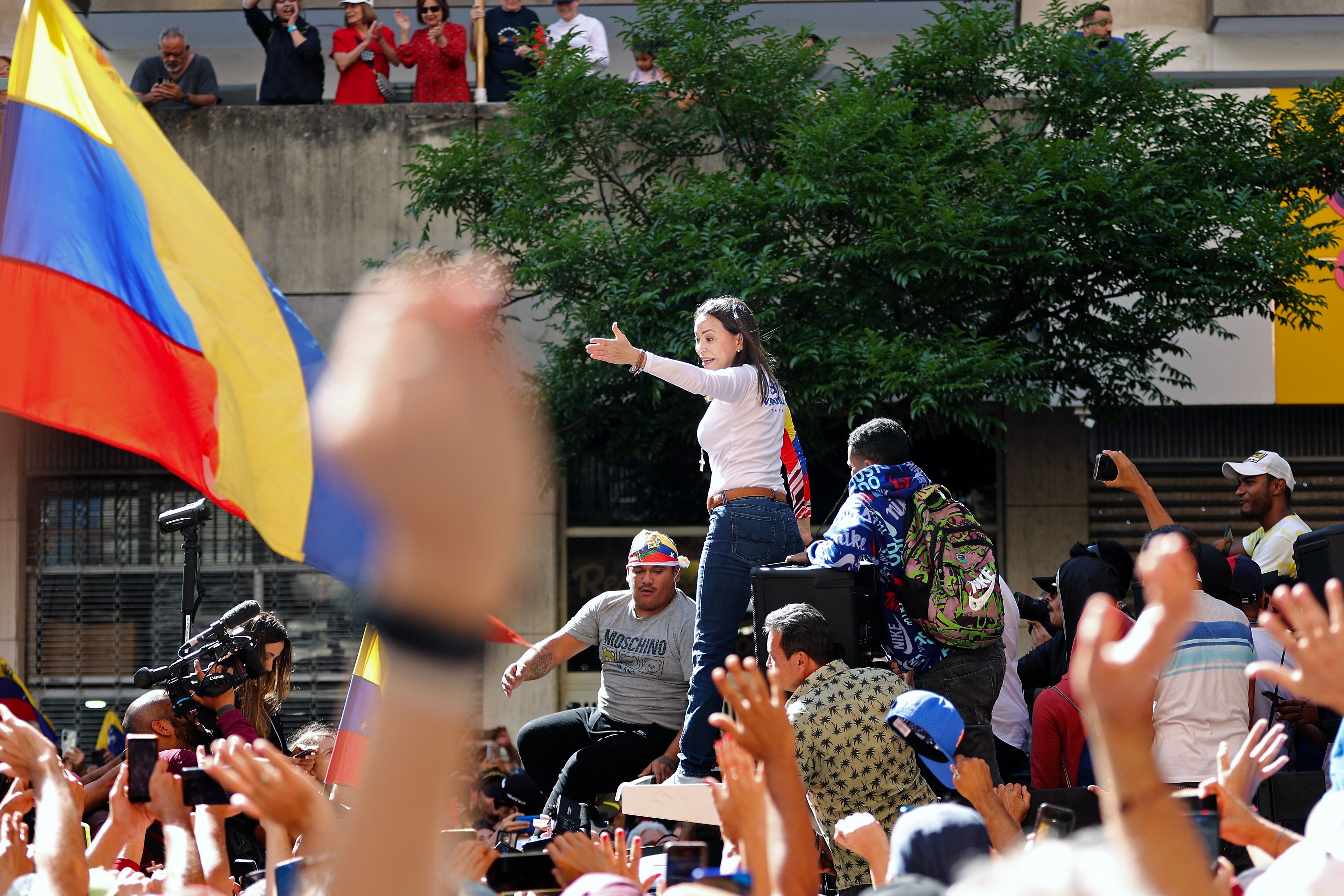 Kobieta w białej bluzce przemawia do tłumu na demonstracji