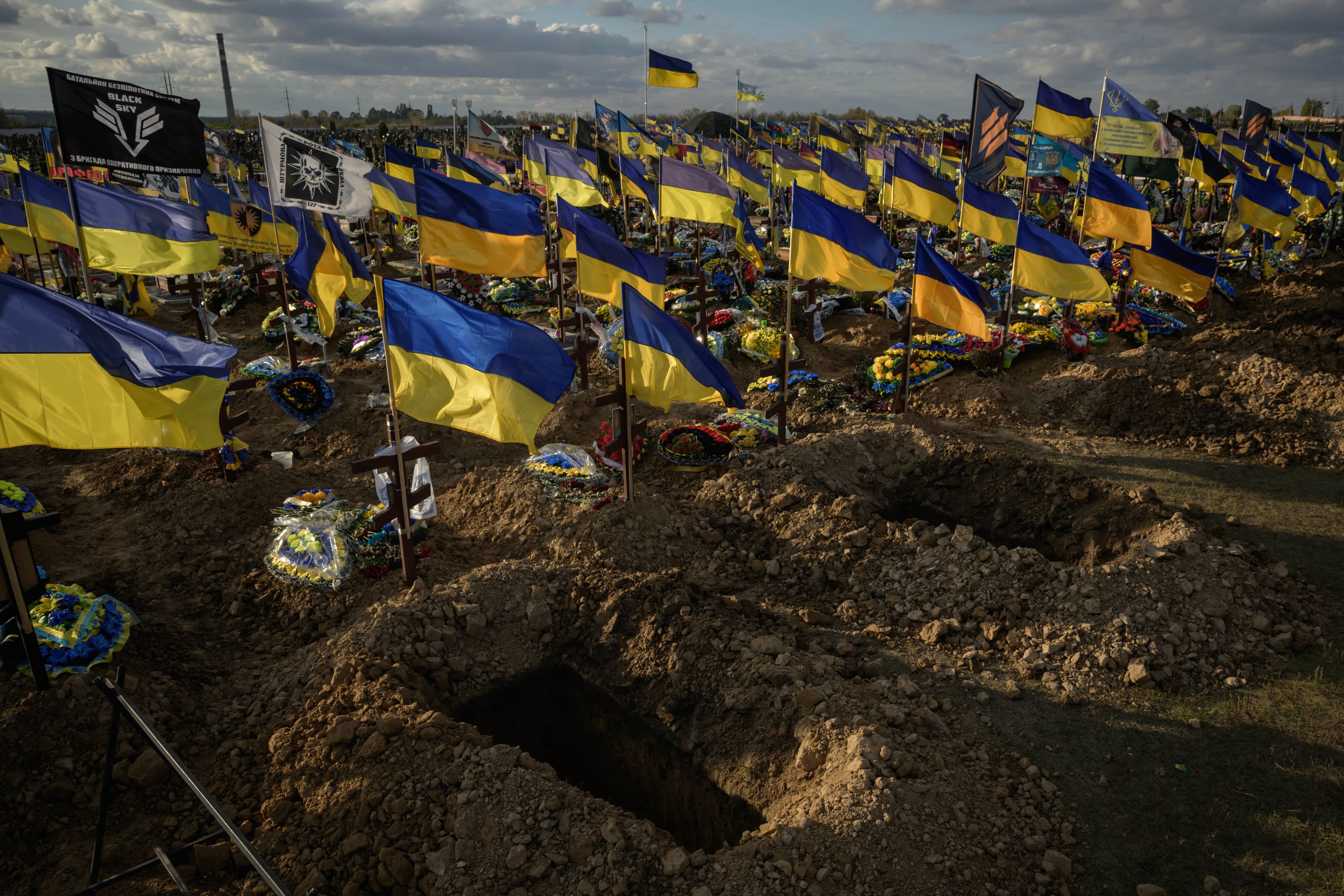 Na zdjęciu jest cmentarz, na każdym grobie jest flaga żółto-niebieska