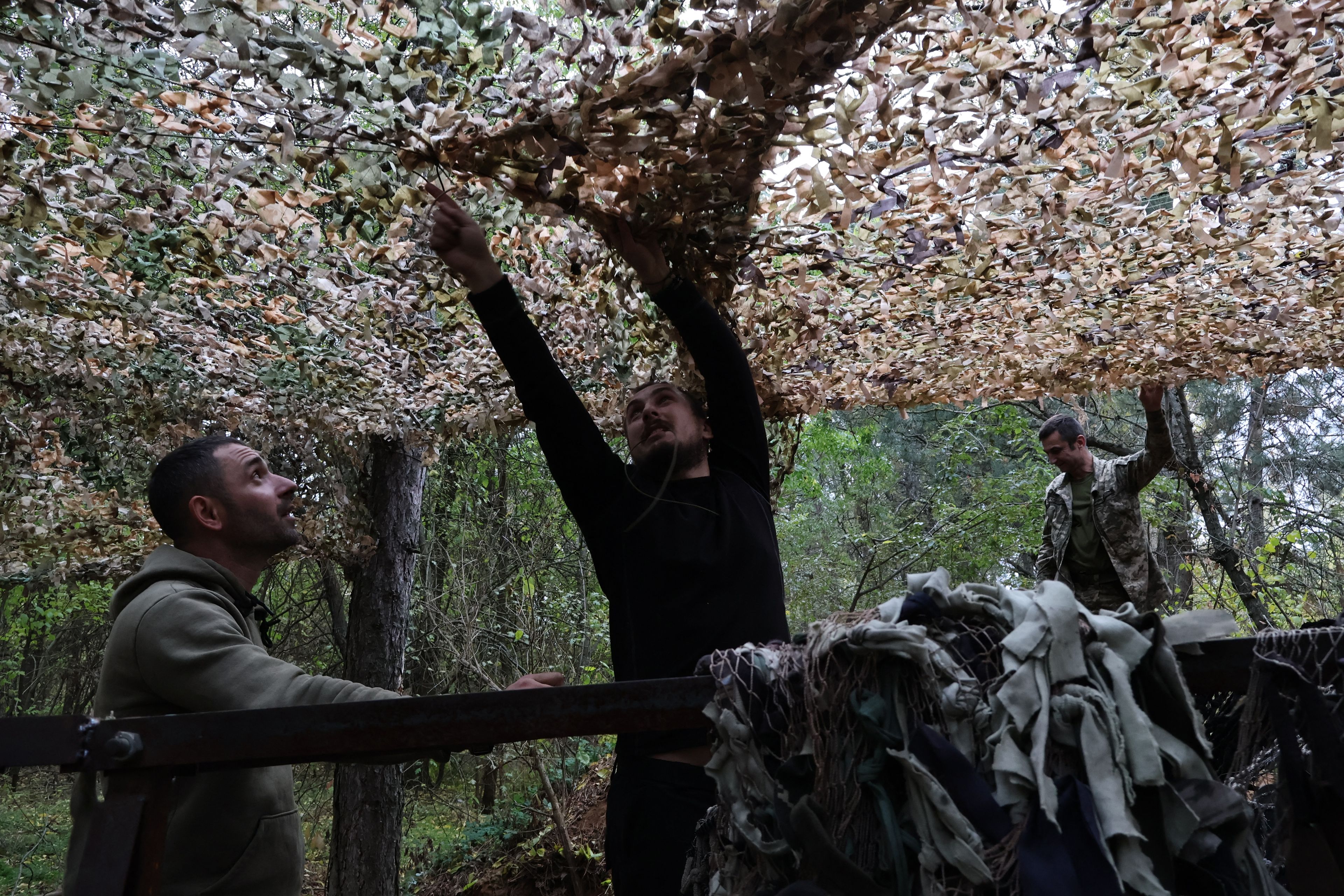 Mężczyźni montujący siatkę maskującą.
