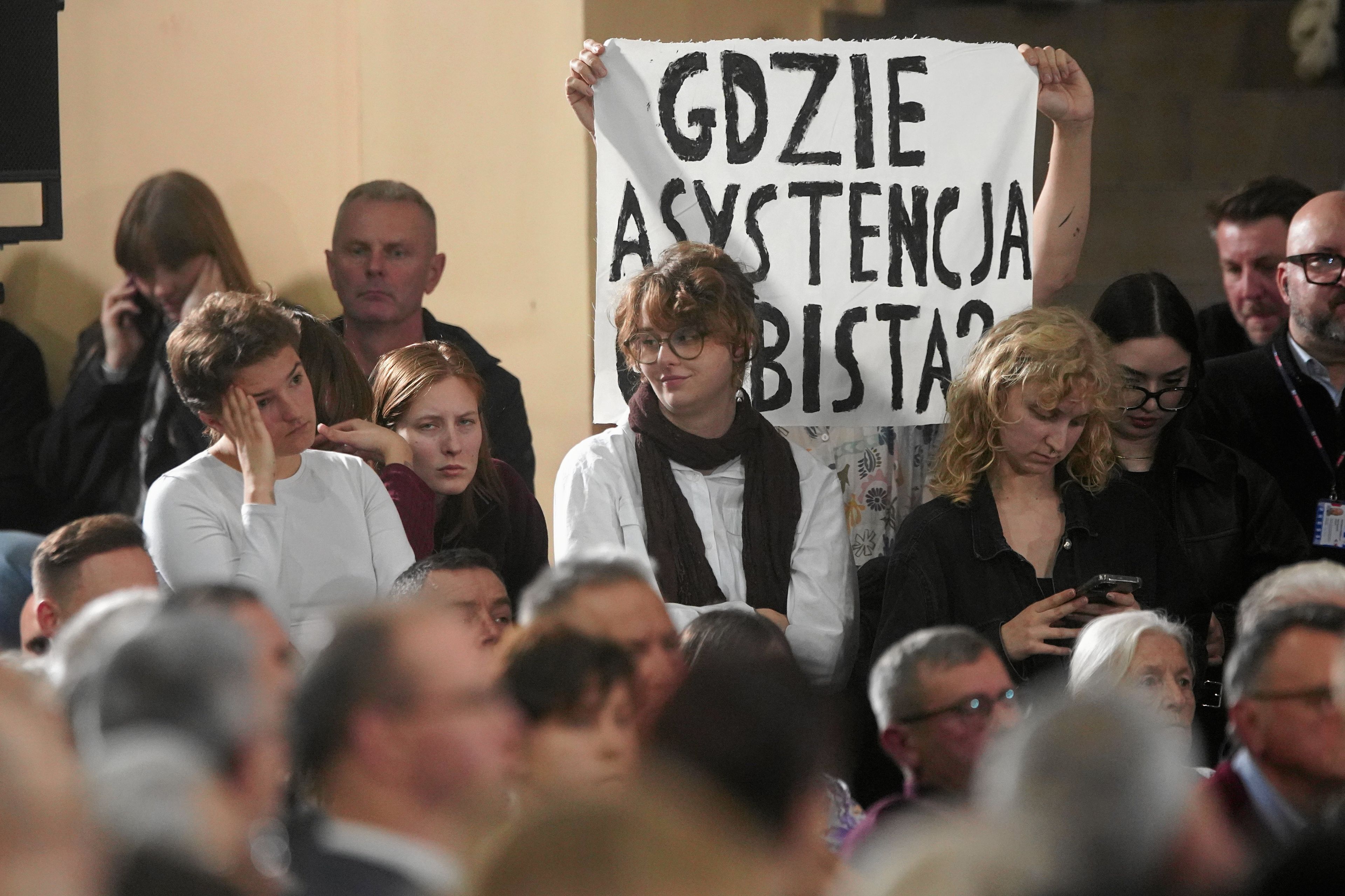 Ludzie z transparentem "Gdzie asystencja osobosta"