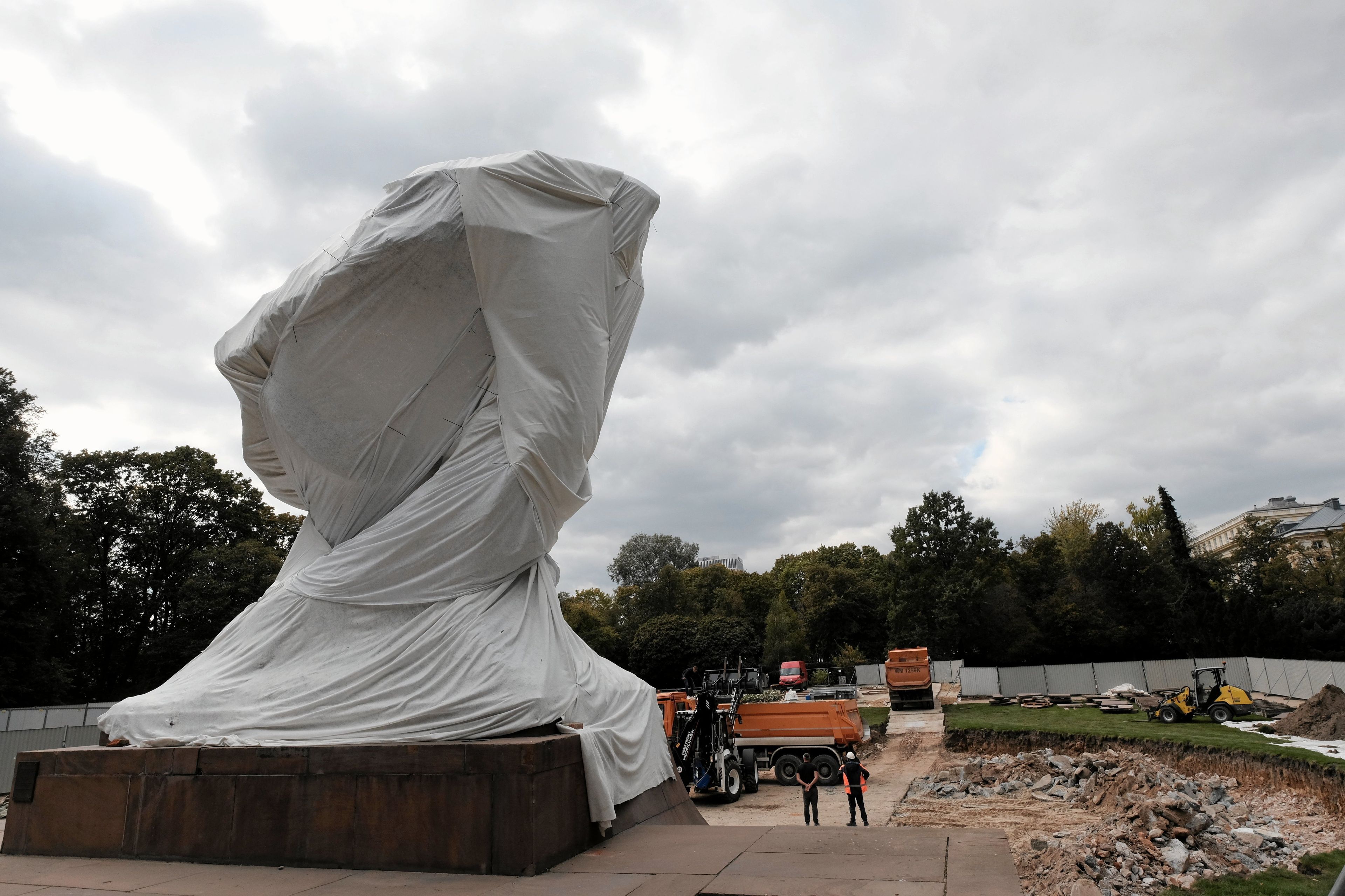 Ekipa remontowa pracuje w niecce przy osłonietym pomniku Chopina w Łazienkach